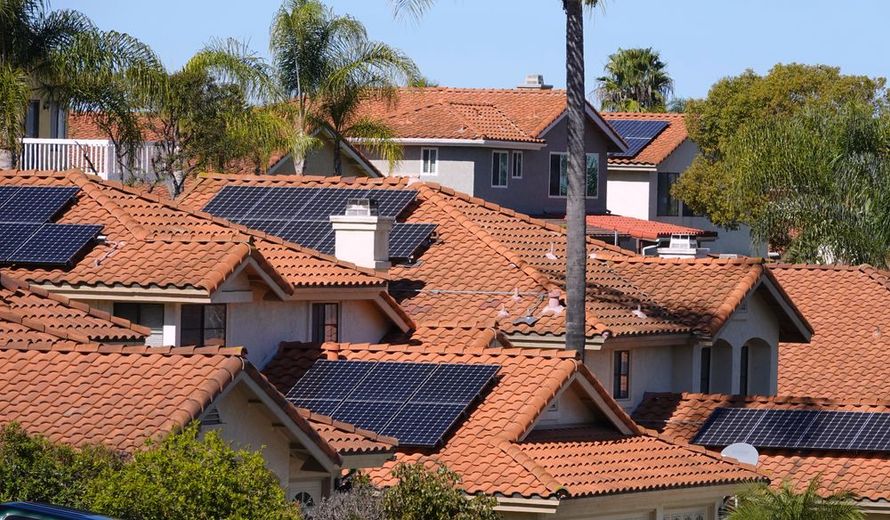 A row of houses with solar panels on their roofs