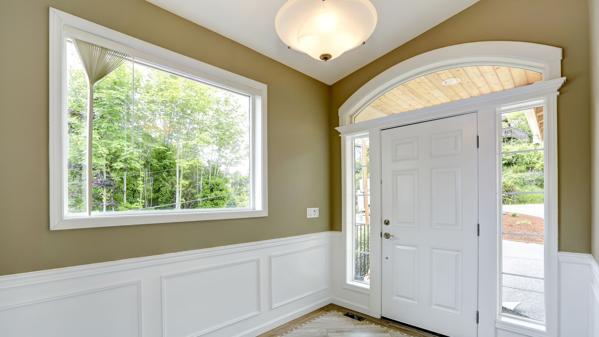 An empty room with a white door and two windows.