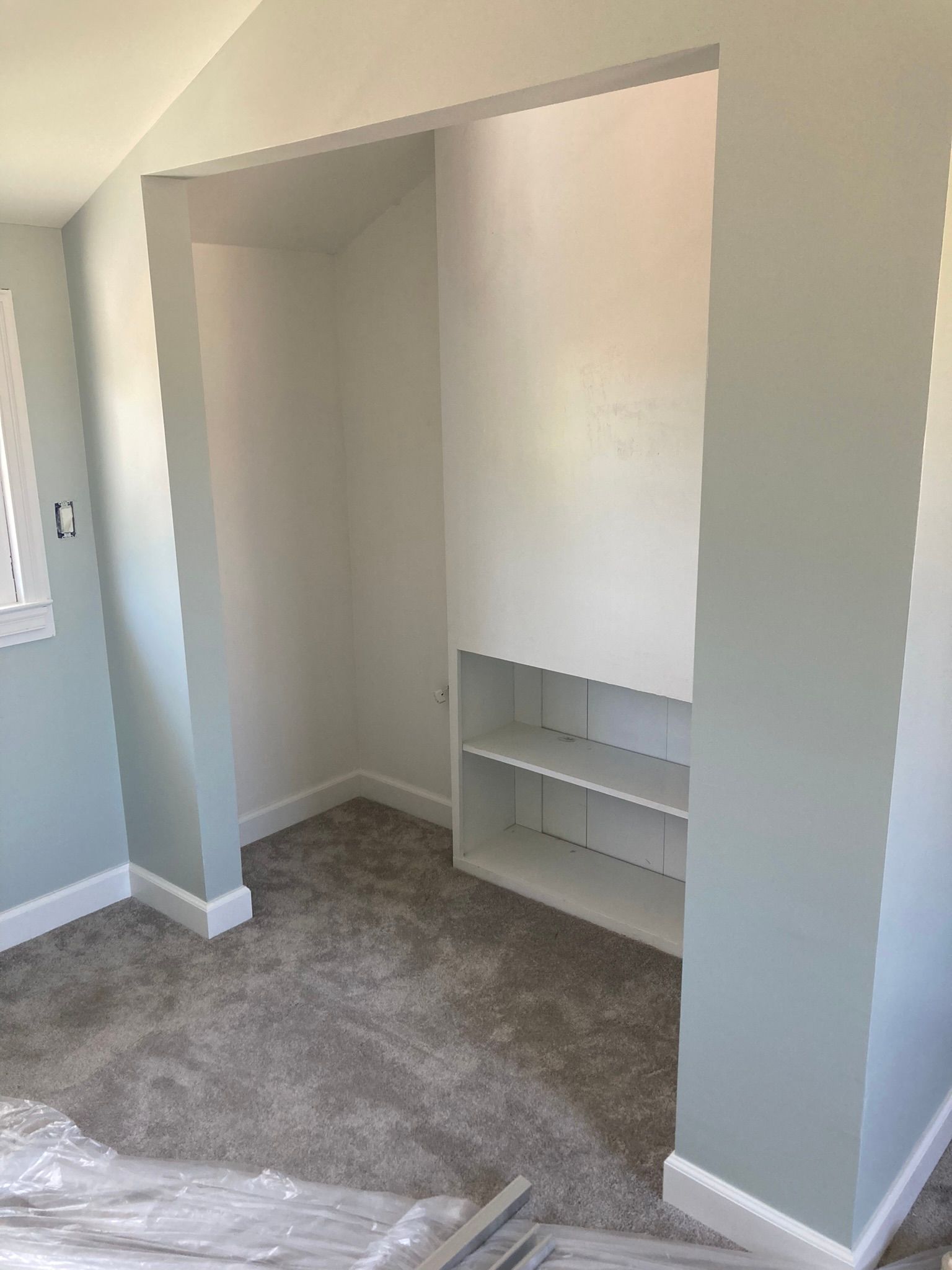 A room with a closet and shelves in it.