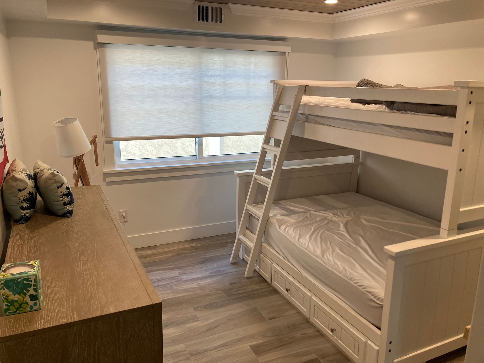 A bedroom with a bunk bed and a desk.