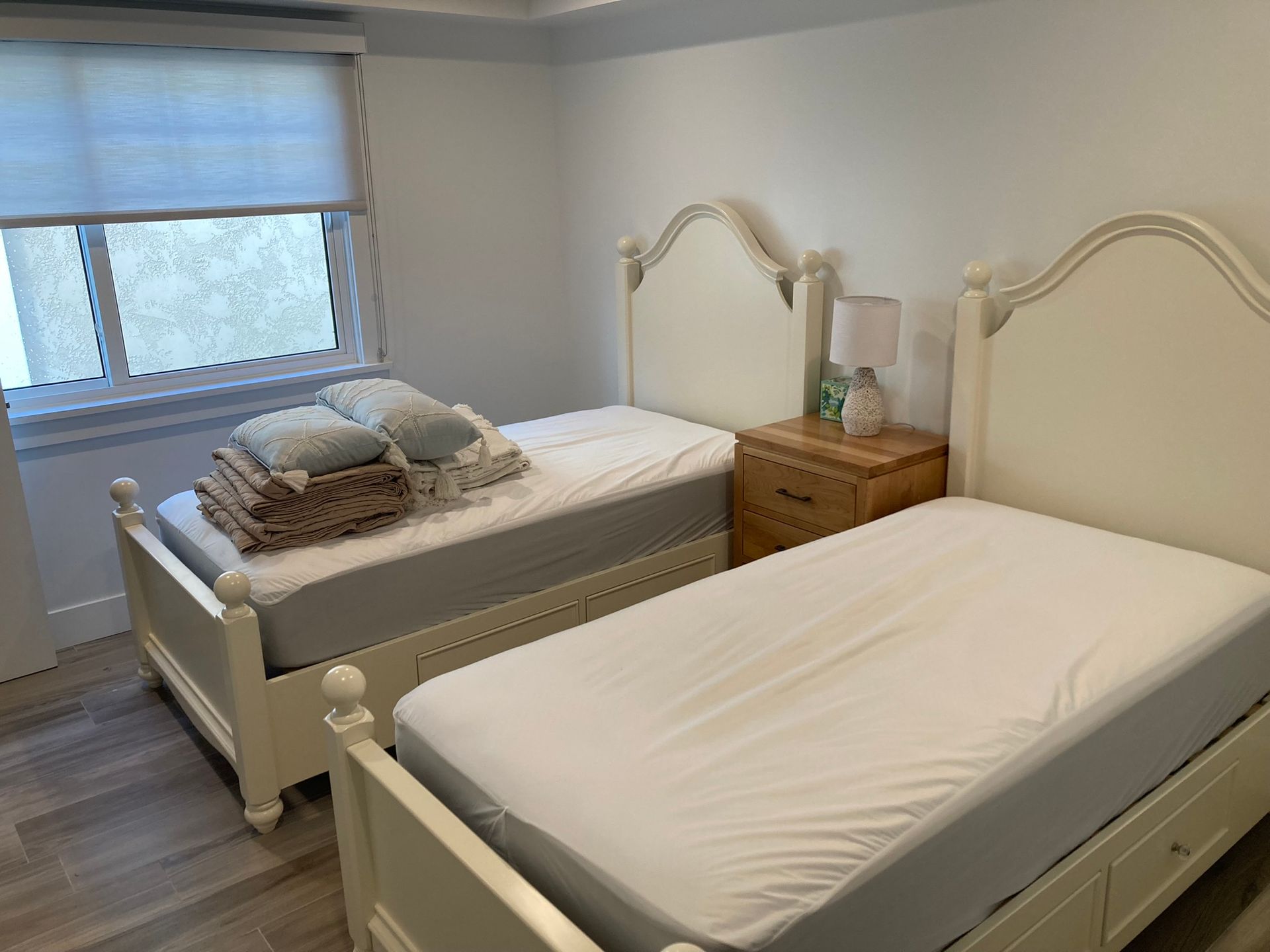 A bedroom with two twin beds and a nightstand.