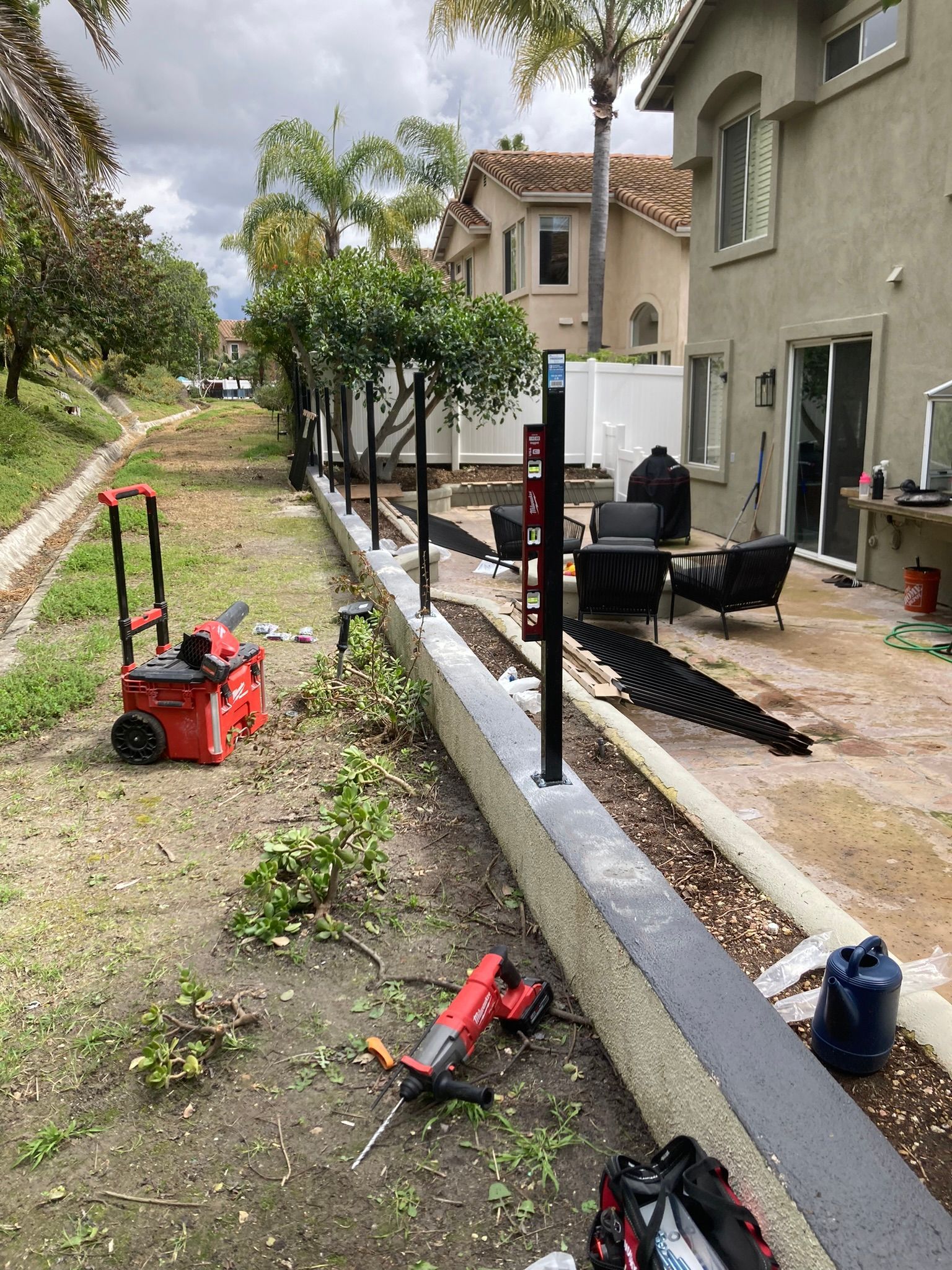 A fence is being built in the backyard of a house.