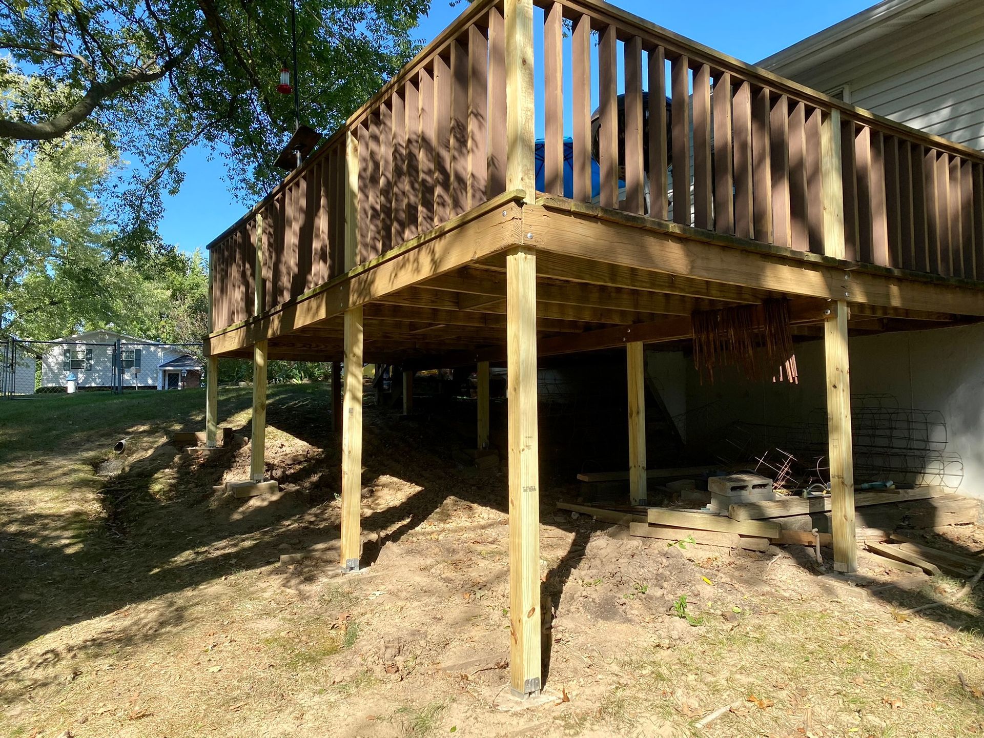 A large wooden deck is sitting underneath a house.