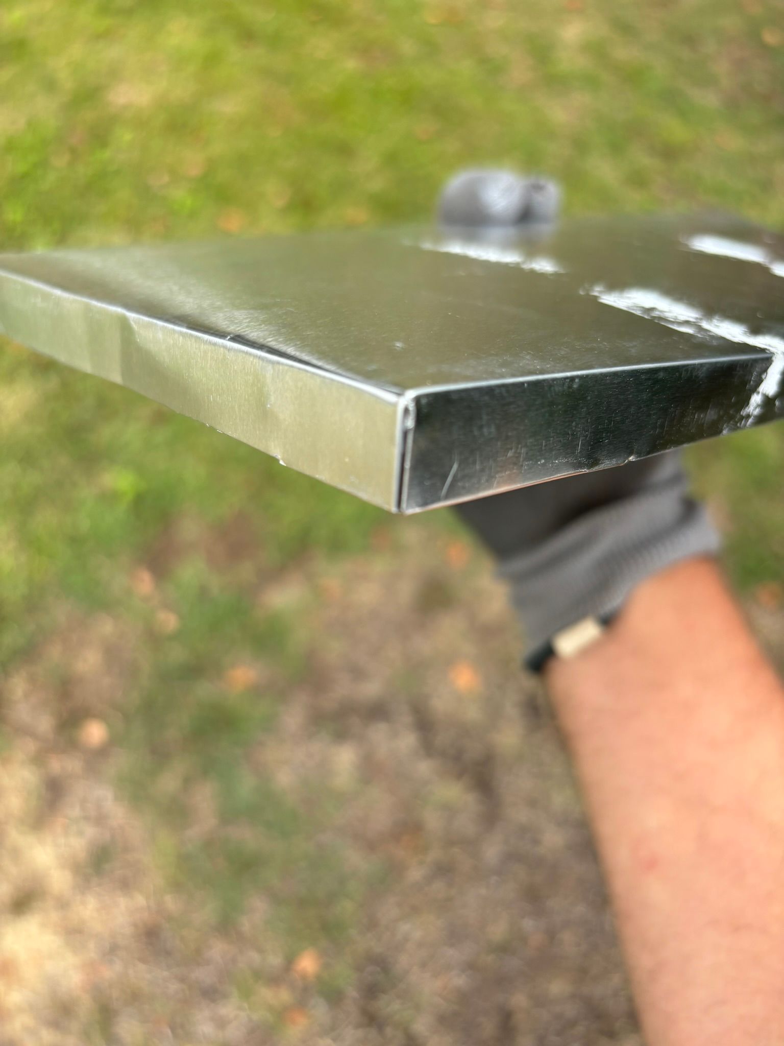 A person is holding a piece of metal in their hand.