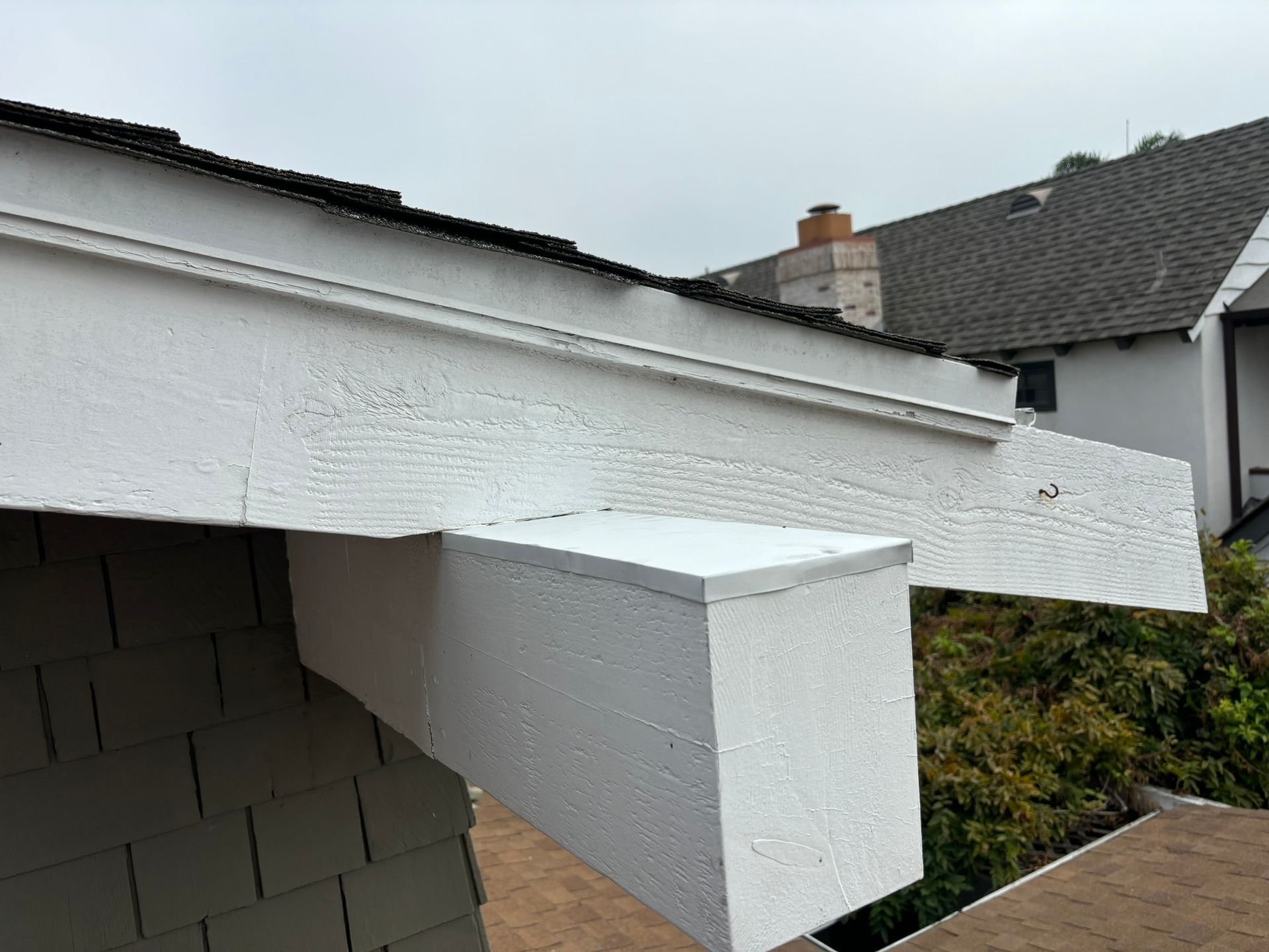 A white roof with a gray roof in the background