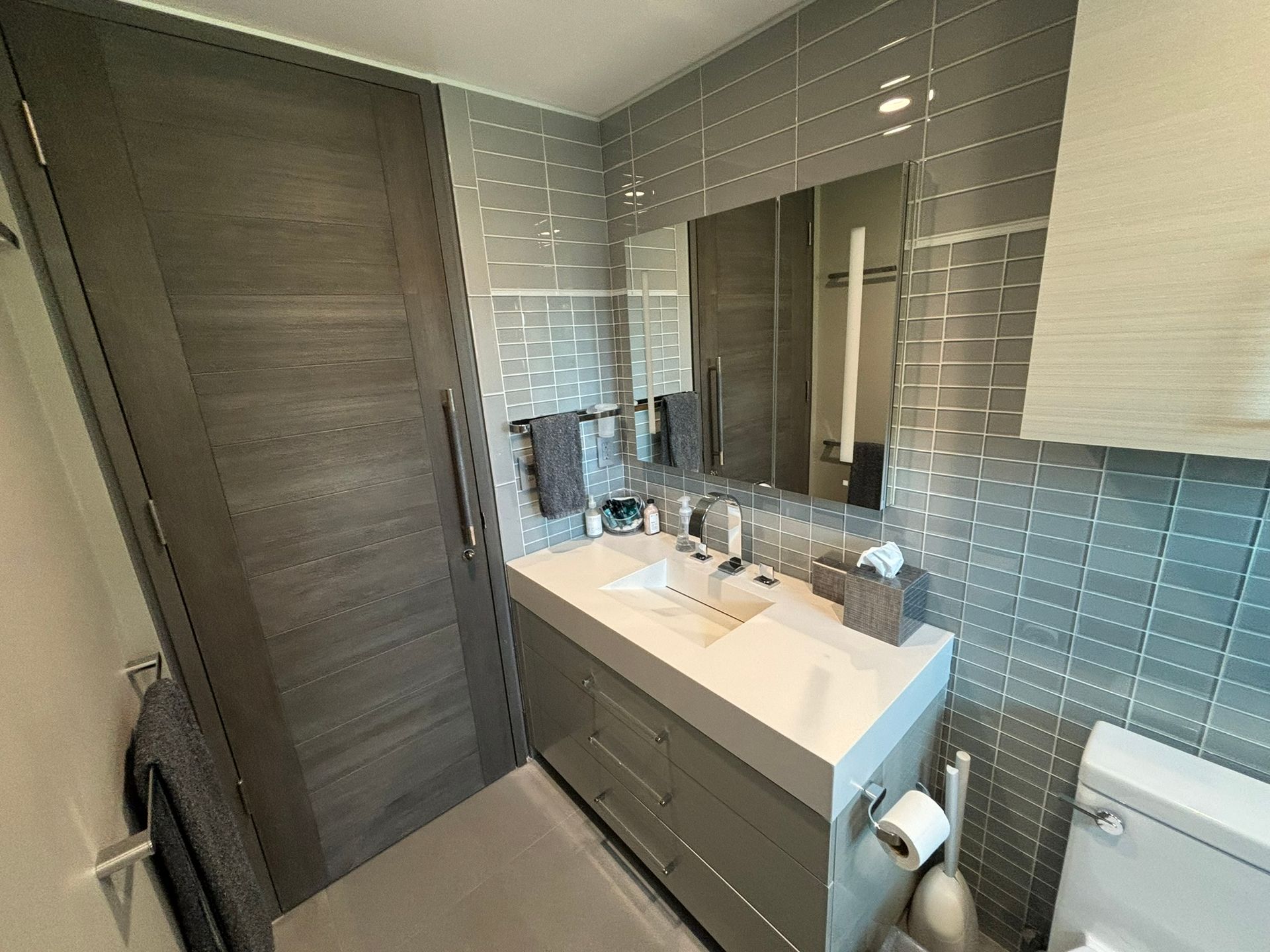 A bathroom with two sinks , a toilet and a mirror.