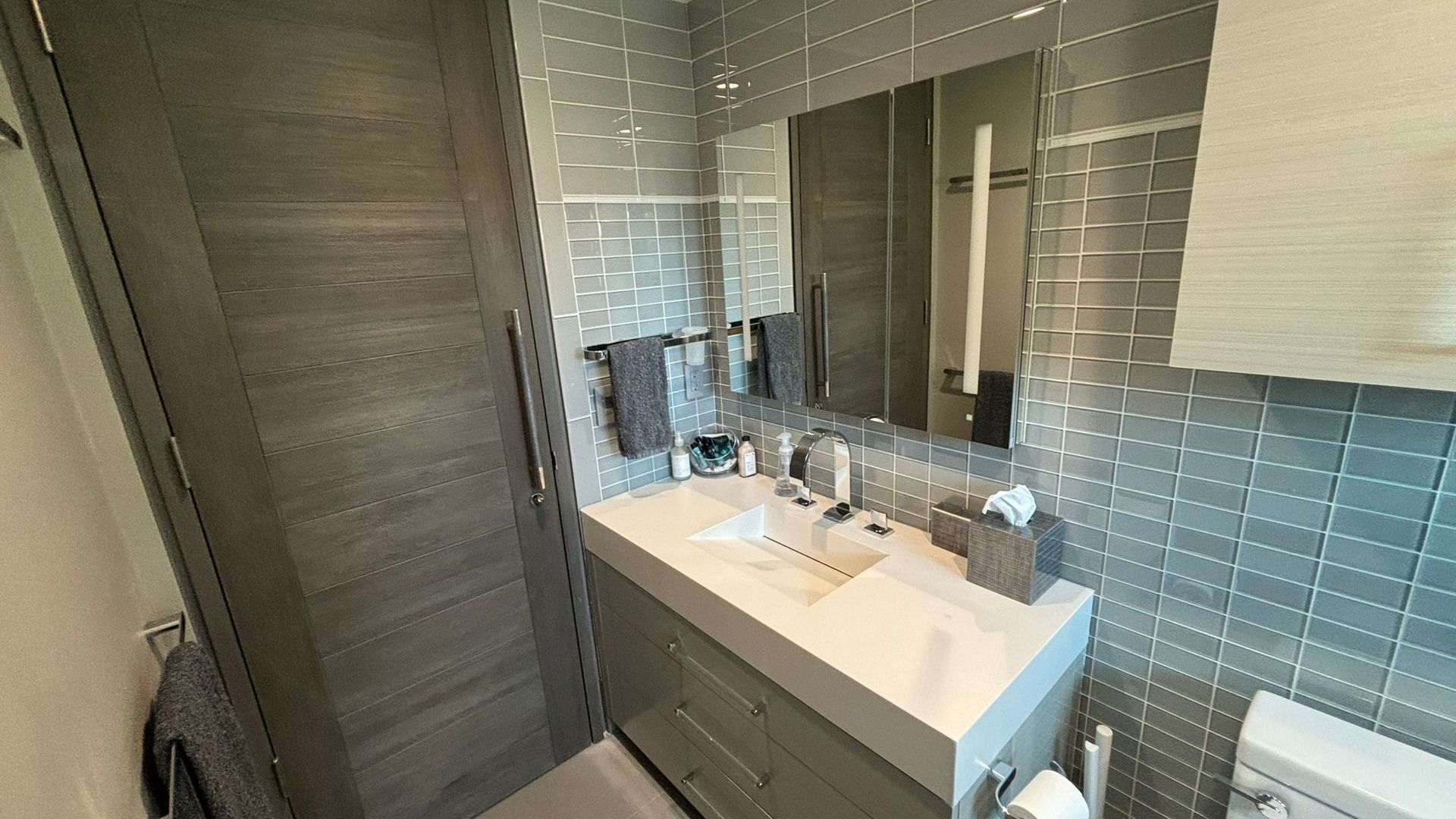 A bathroom with two sinks , a toilet and a mirror.
