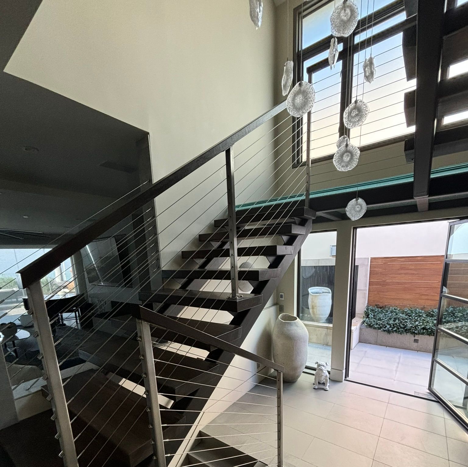 A staircase with a glass railing leading up to the second floor of a house.