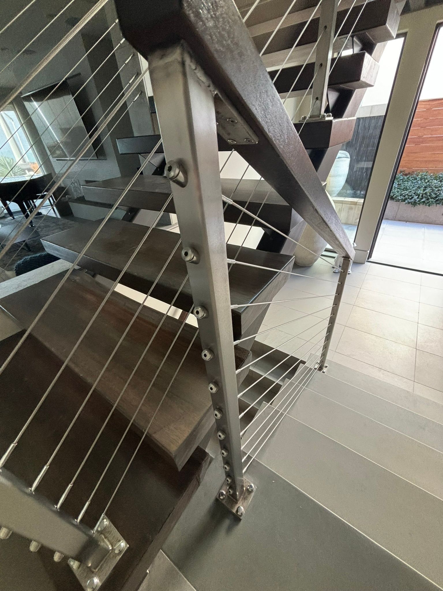 A close up of a staircase with a stainless steel railing