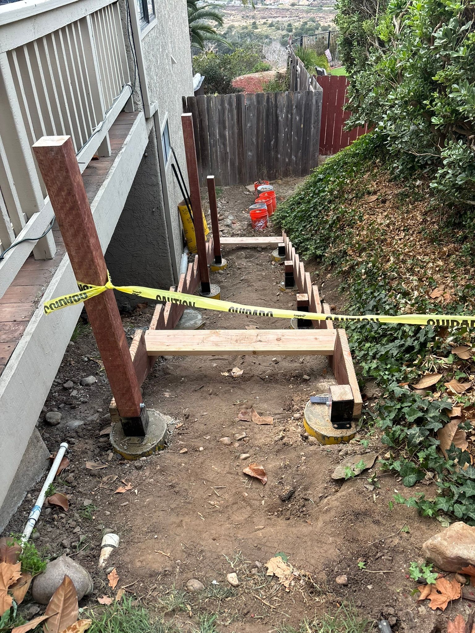 A wooden staircase is being built next to a house.