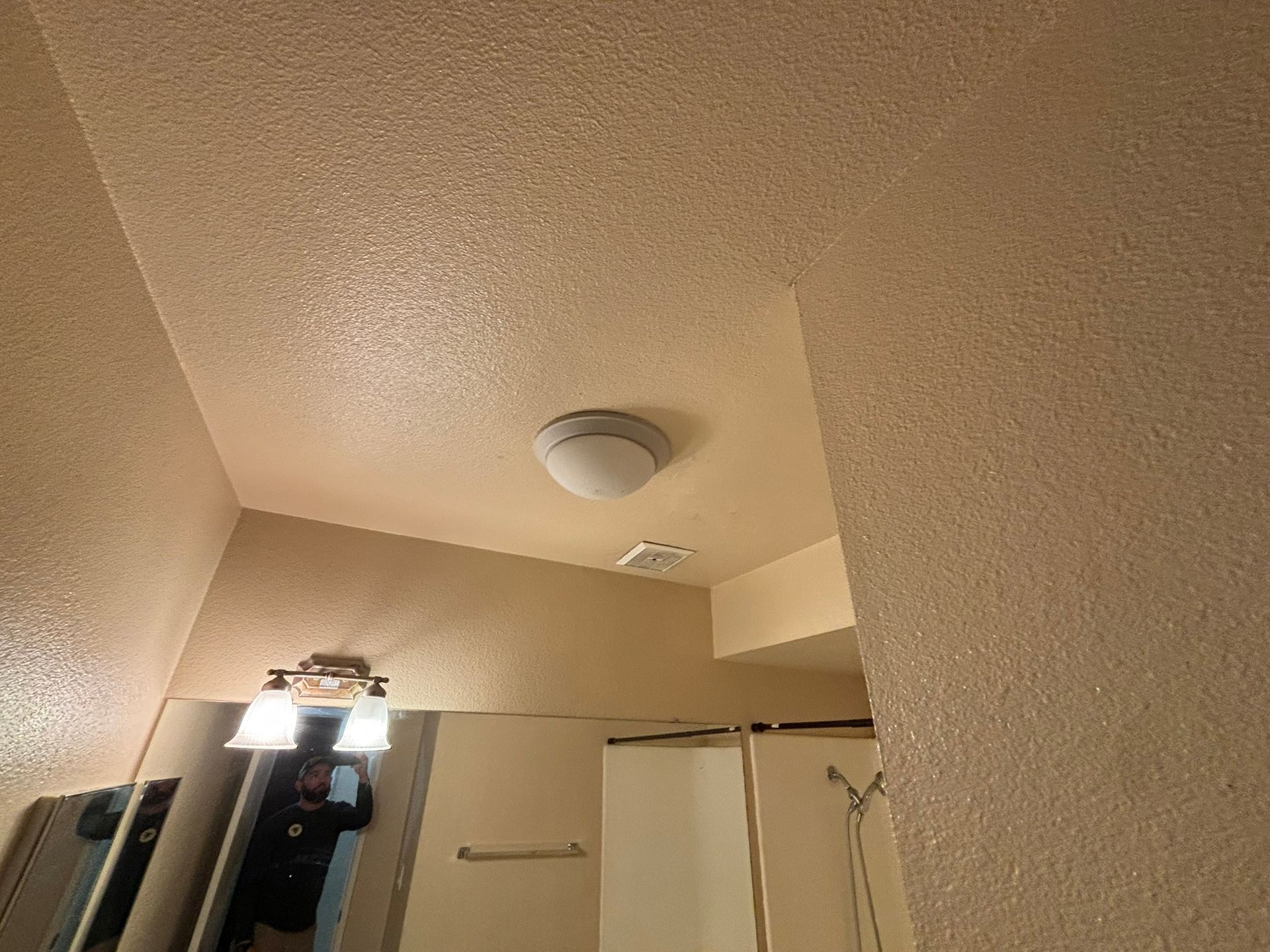 A bathroom with a mirror and a light on the ceiling