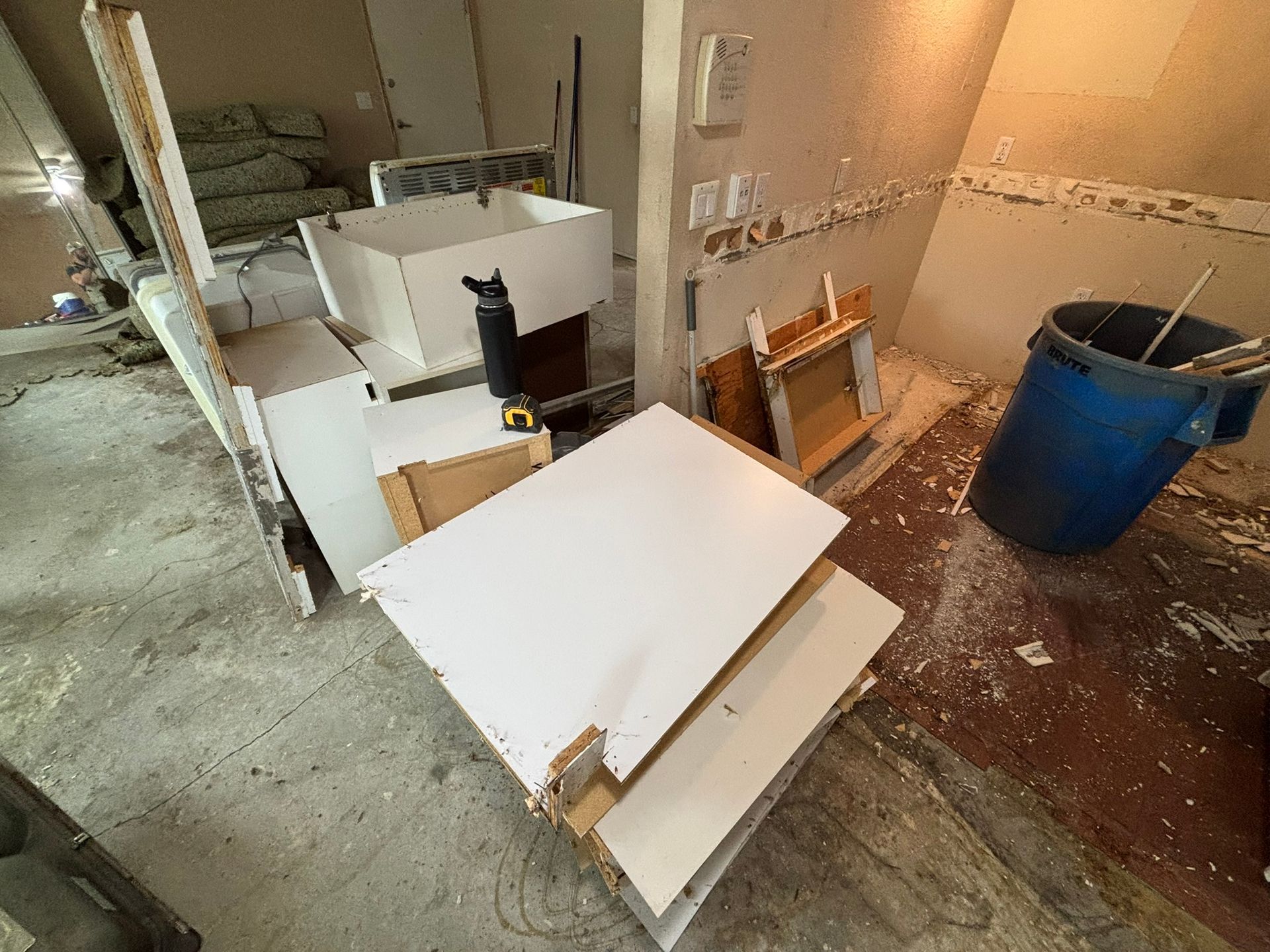 A bathroom under construction with a sink and a trash can.