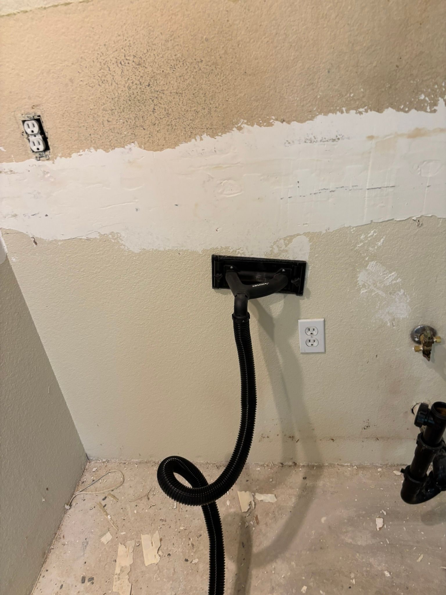 A vacuum cleaner is attached to a wall in a room.