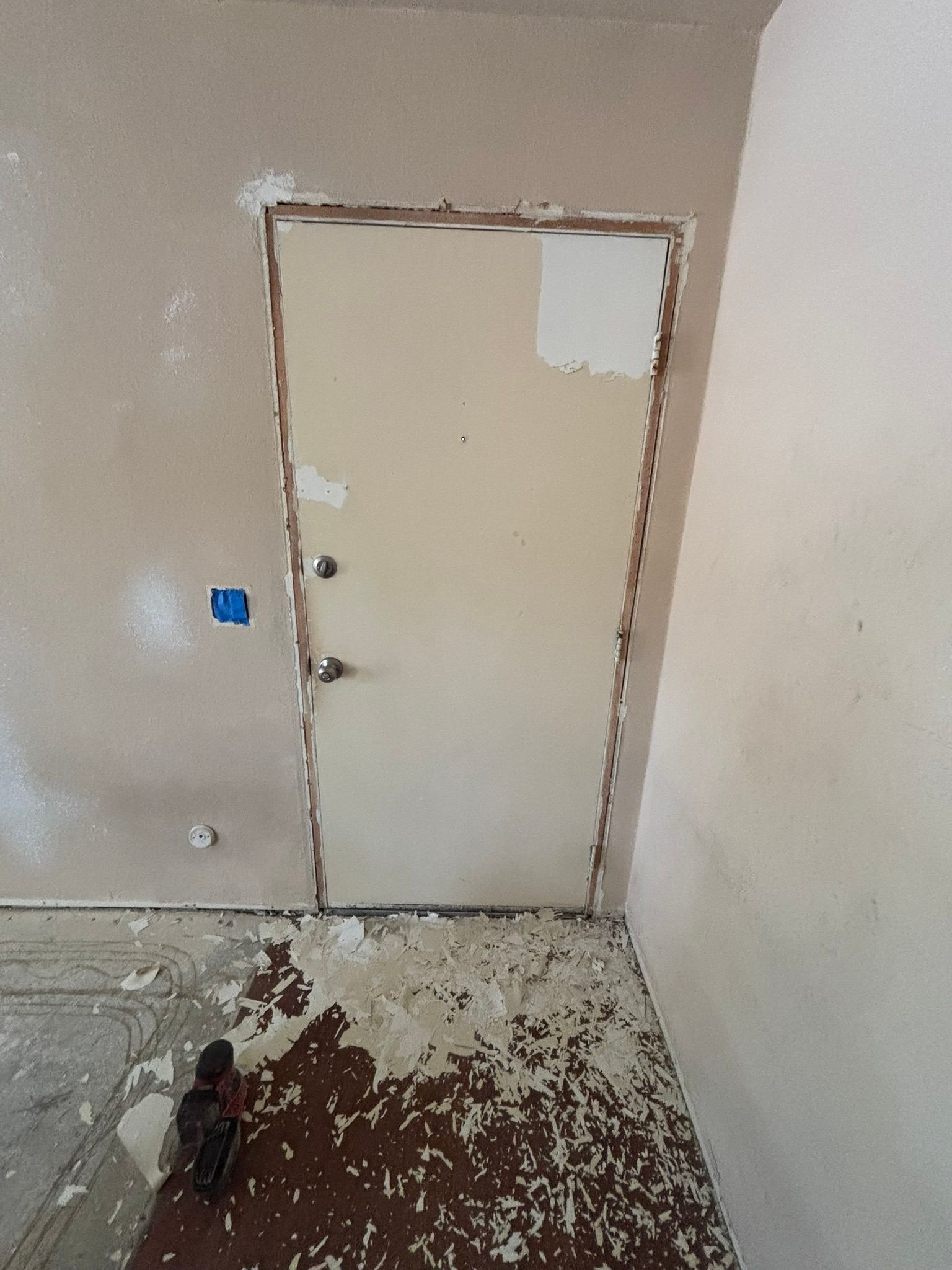 A room with a door in it and a dirty floor.