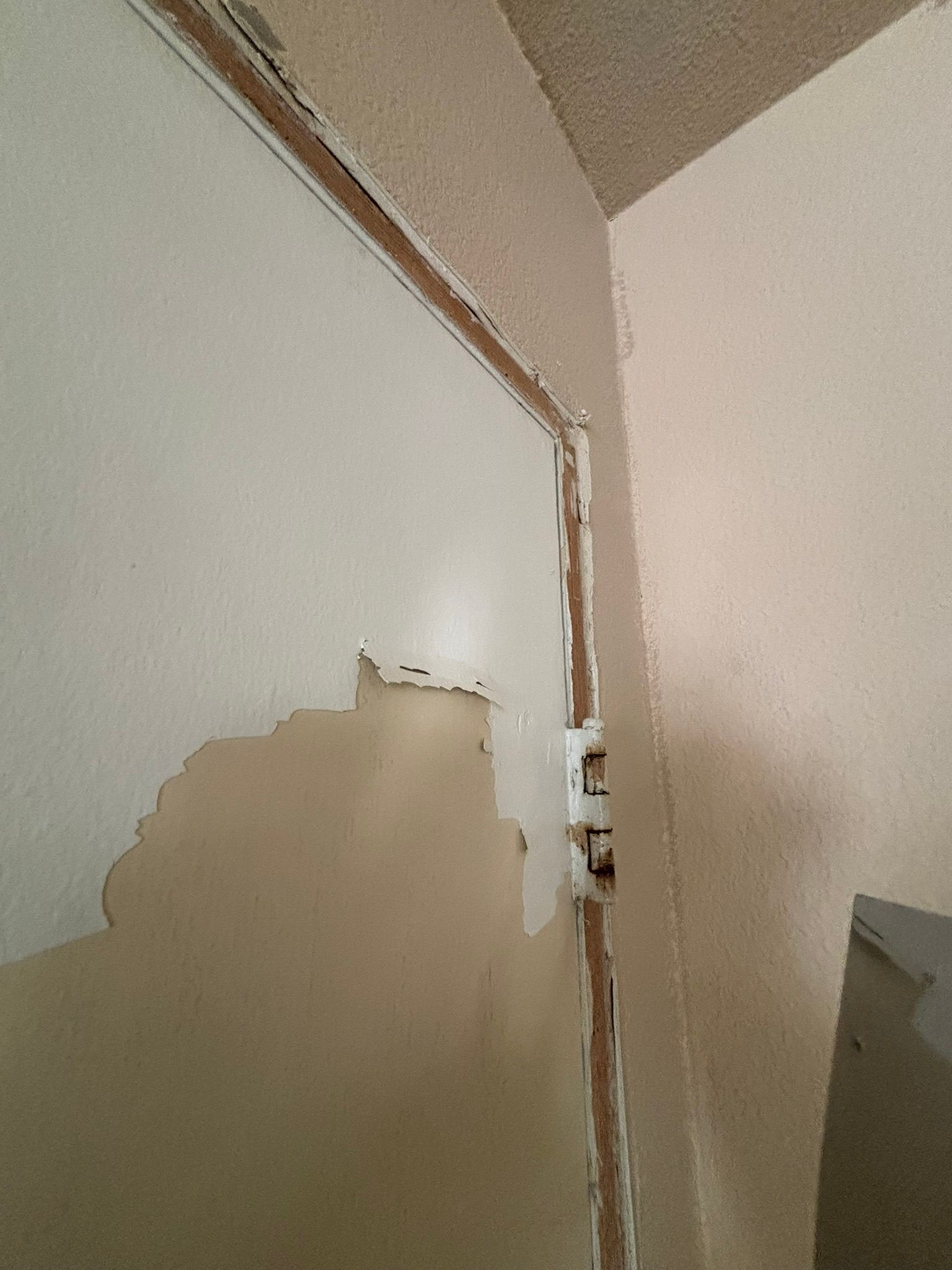 A door with a hole in it is being painted white