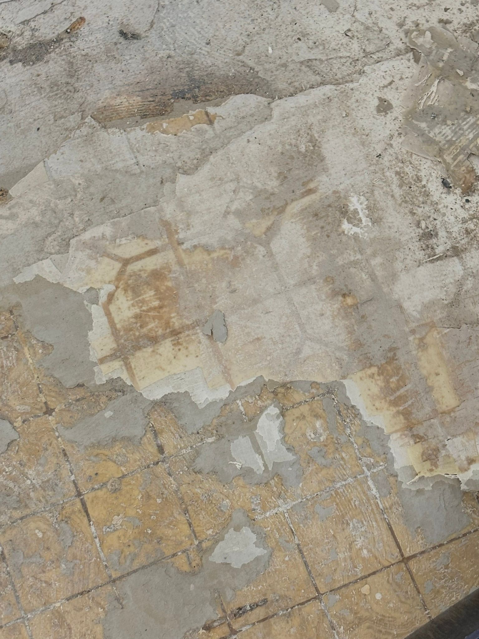 A close up of a tiled floor with peeling paint on it.