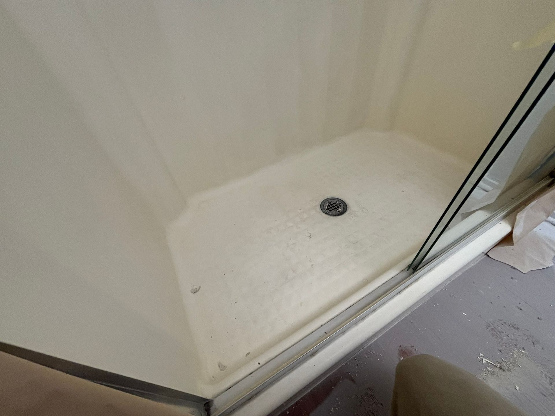 A shower stall with a sliding glass door in a bathroom.