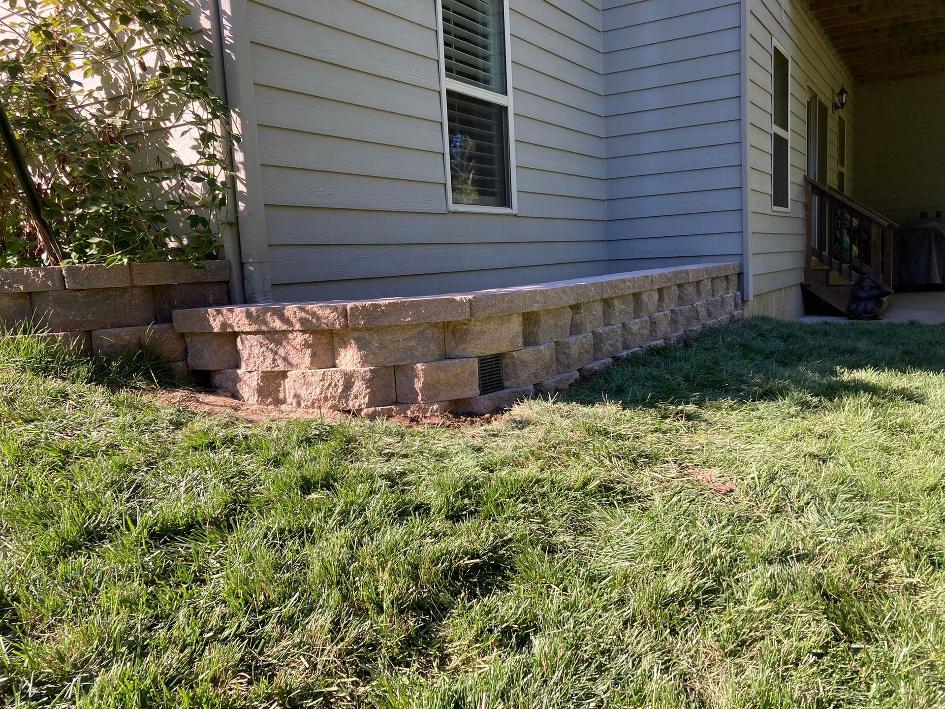 A house with a stone wall in front of it