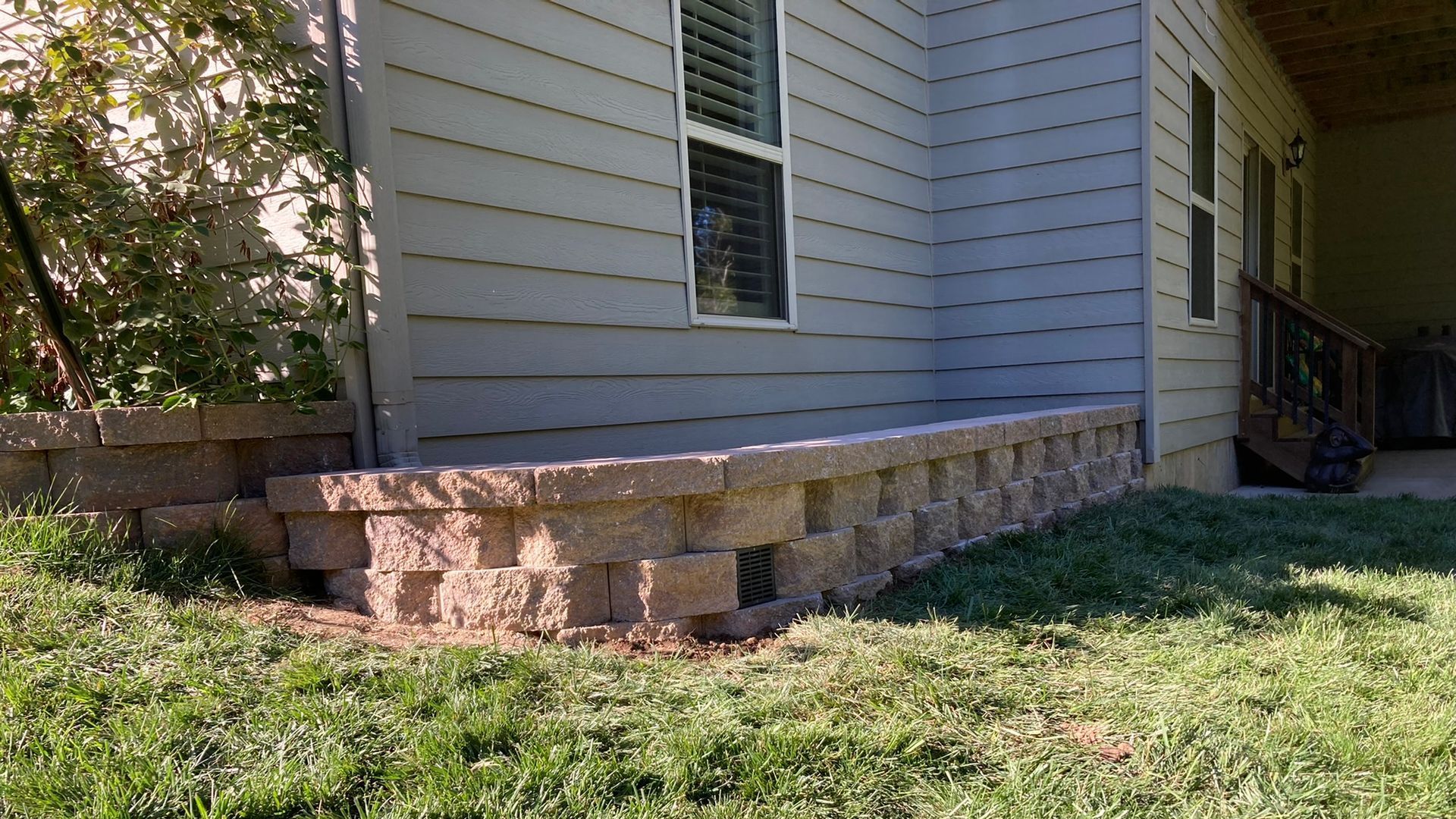 A house with a stone wall in front of it