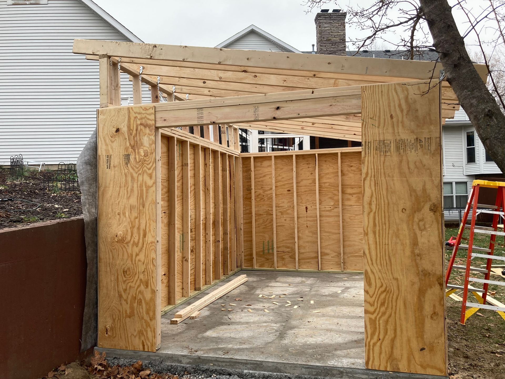 A wooden structure is being built in front of a house.