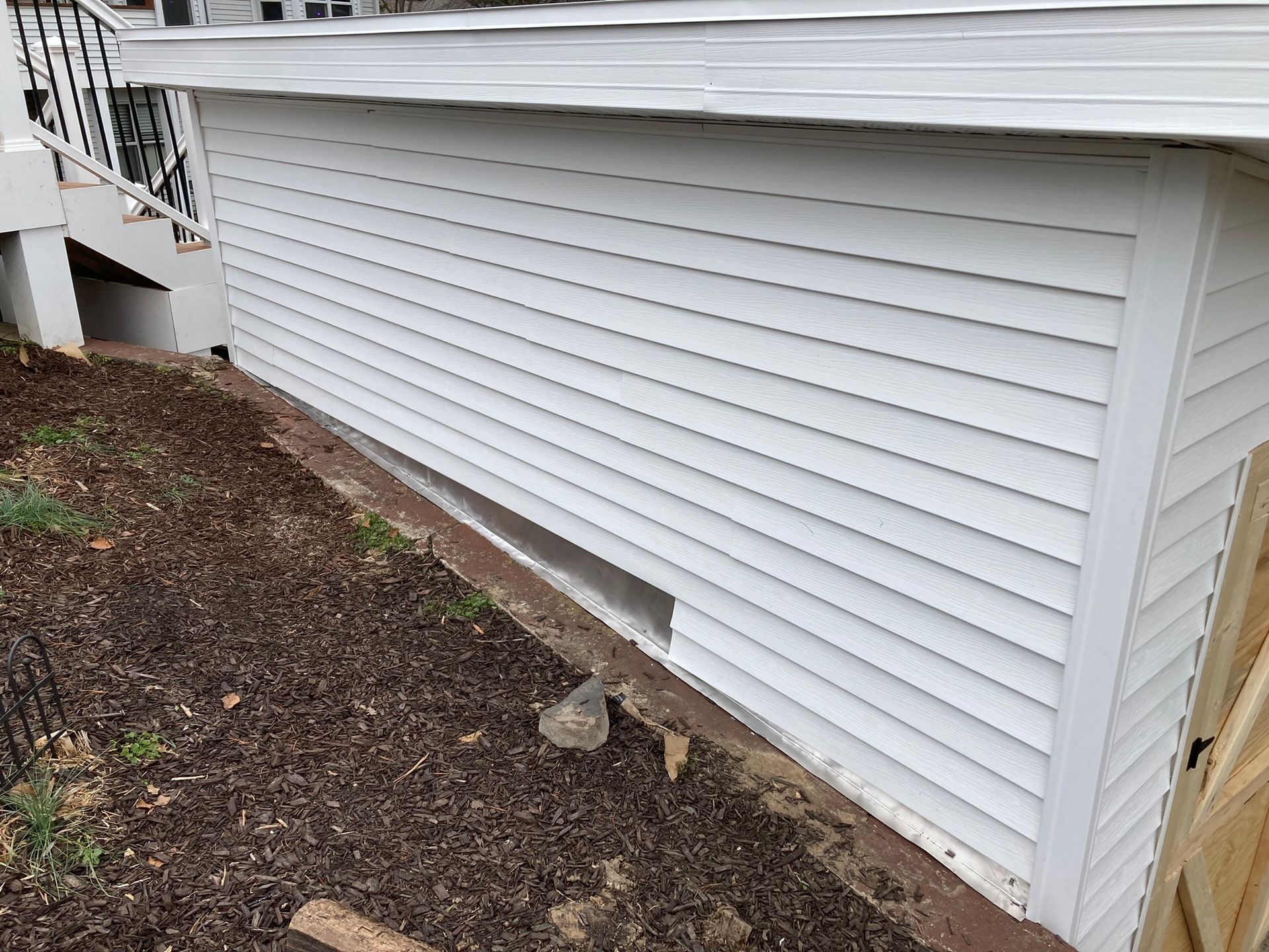 A white house with a window on the side of it.