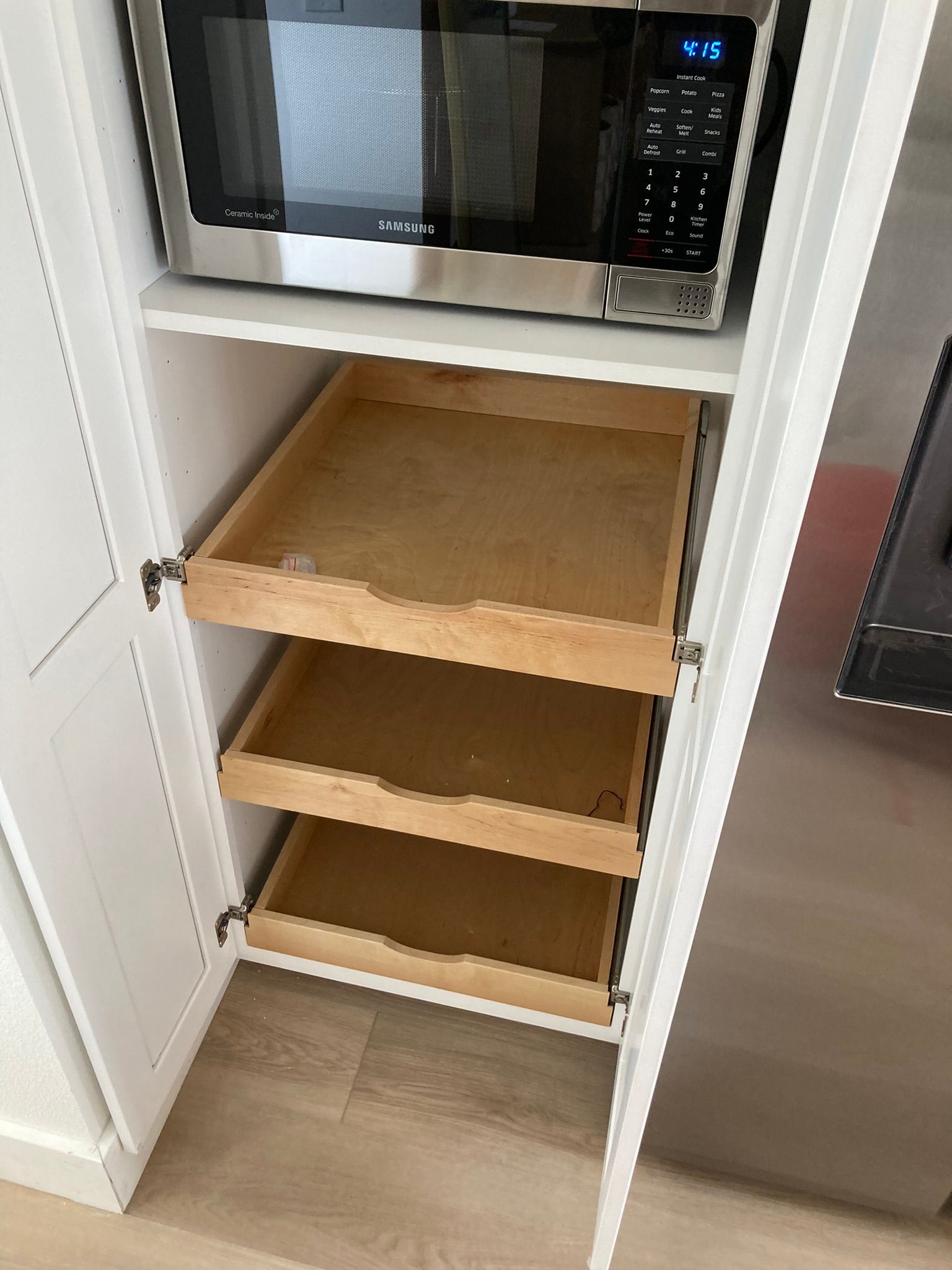 A microwave oven is sitting on top of a shelf in a kitchen.