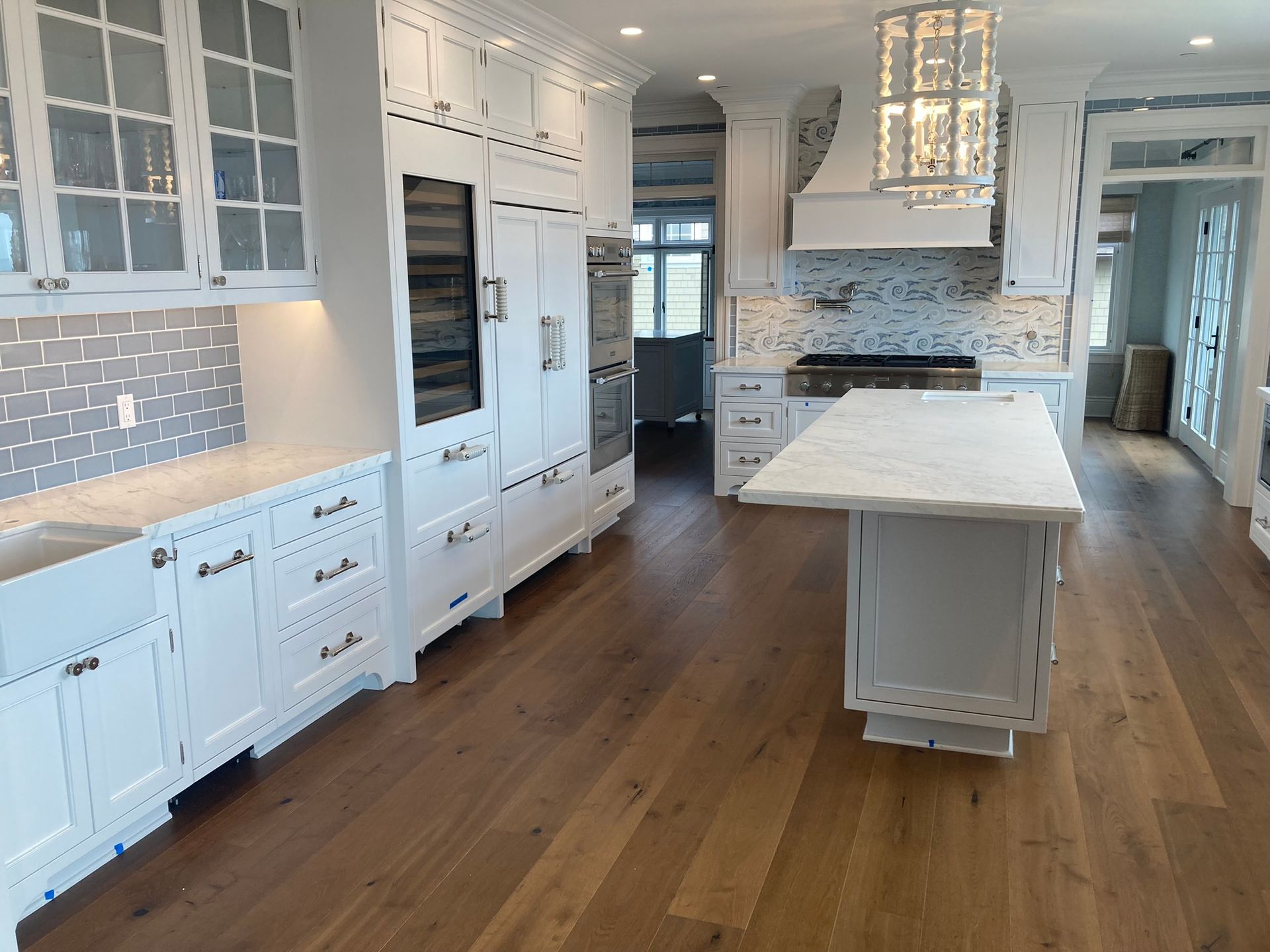 A large kitchen with white cabinets and hardwood floors