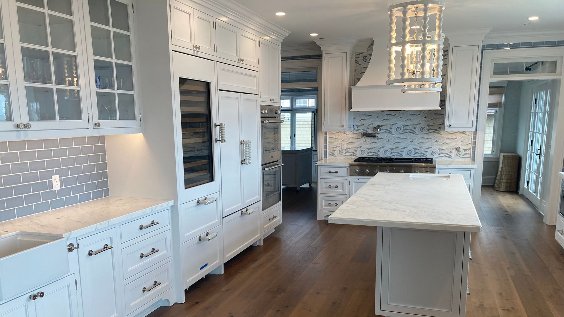 A large kitchen with white cabinets and hardwood floors