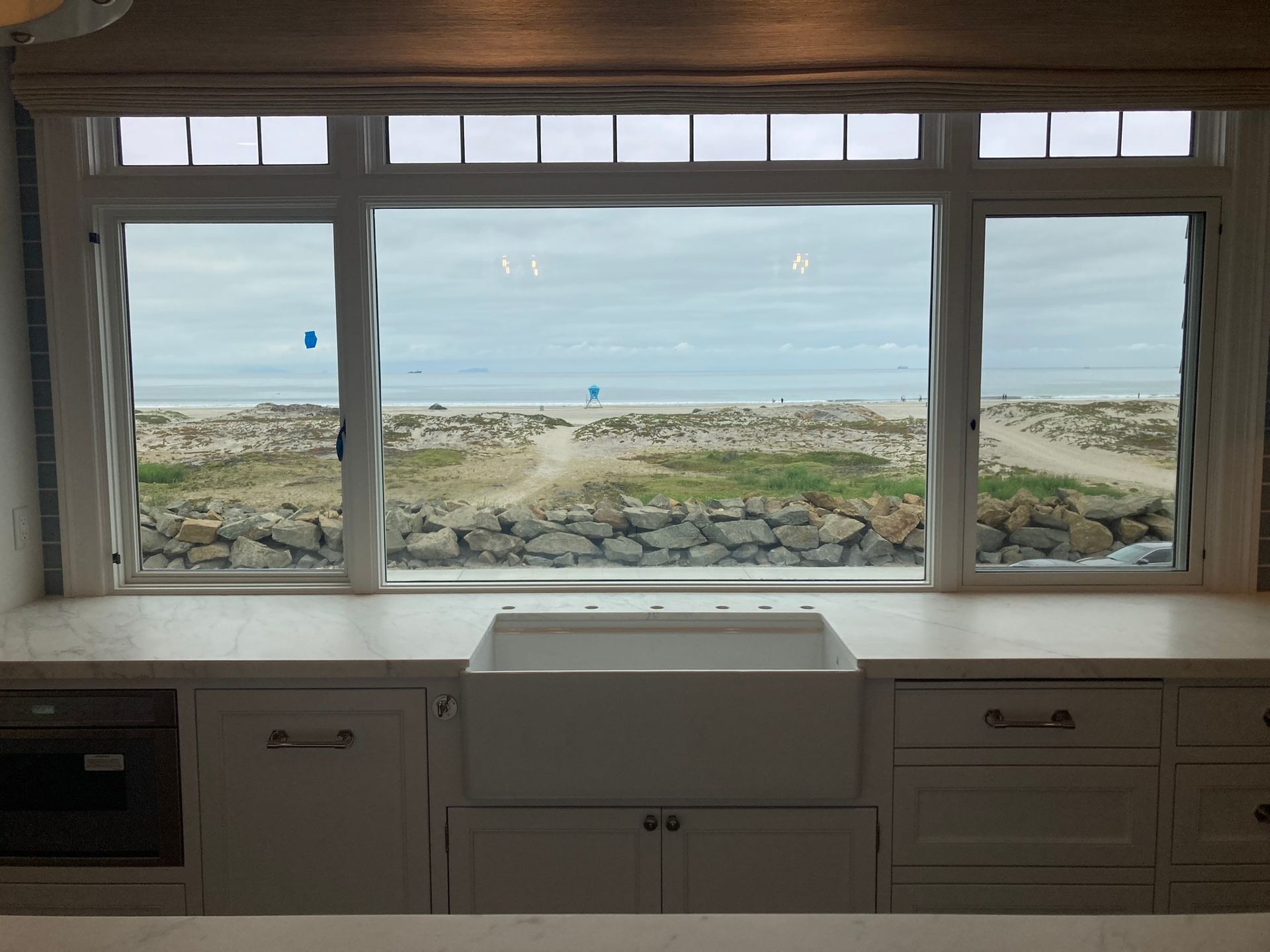 A kitchen with a sink and a view of the ocean