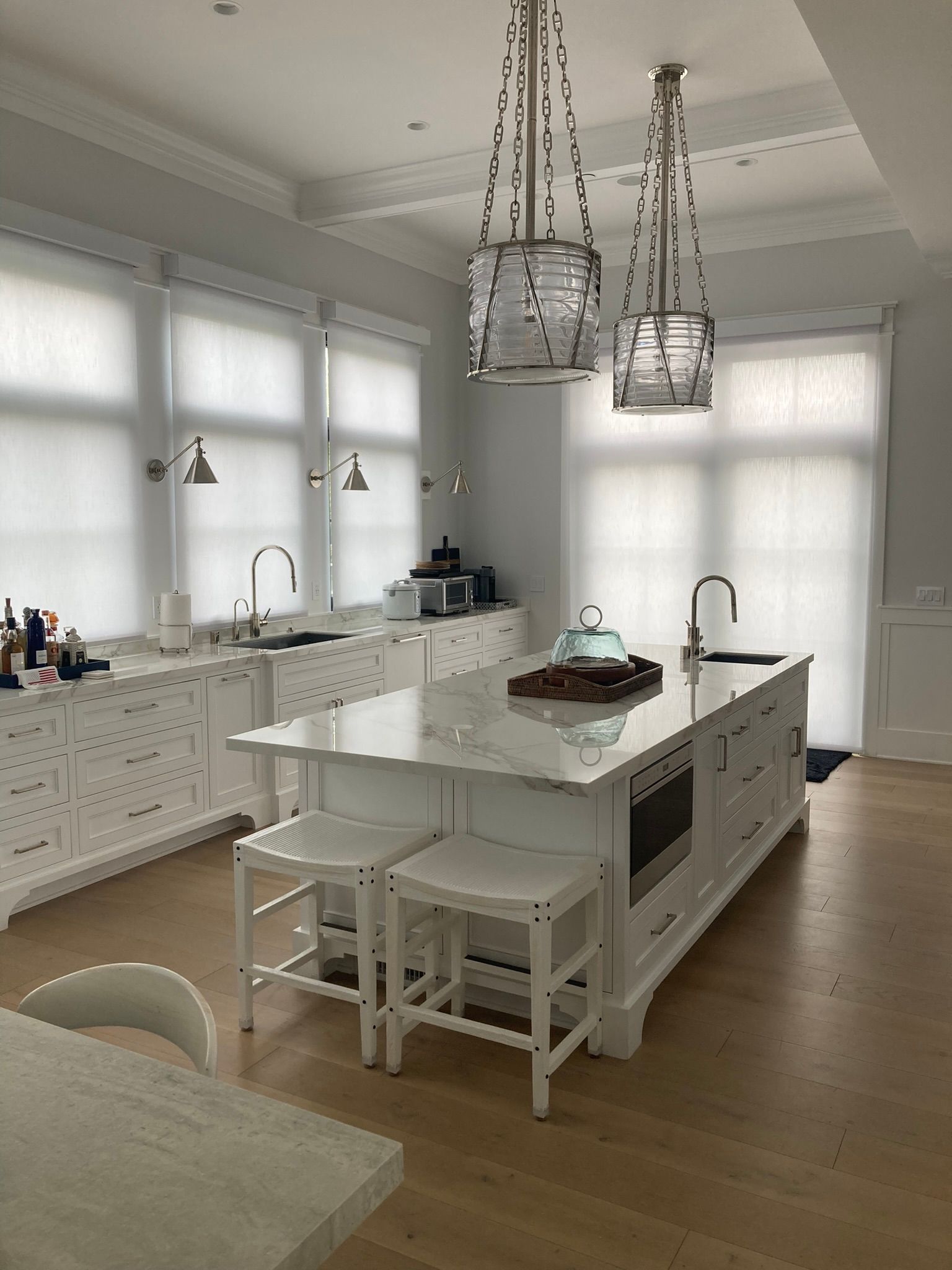 A kitchen with white cabinets and a large island in the middle