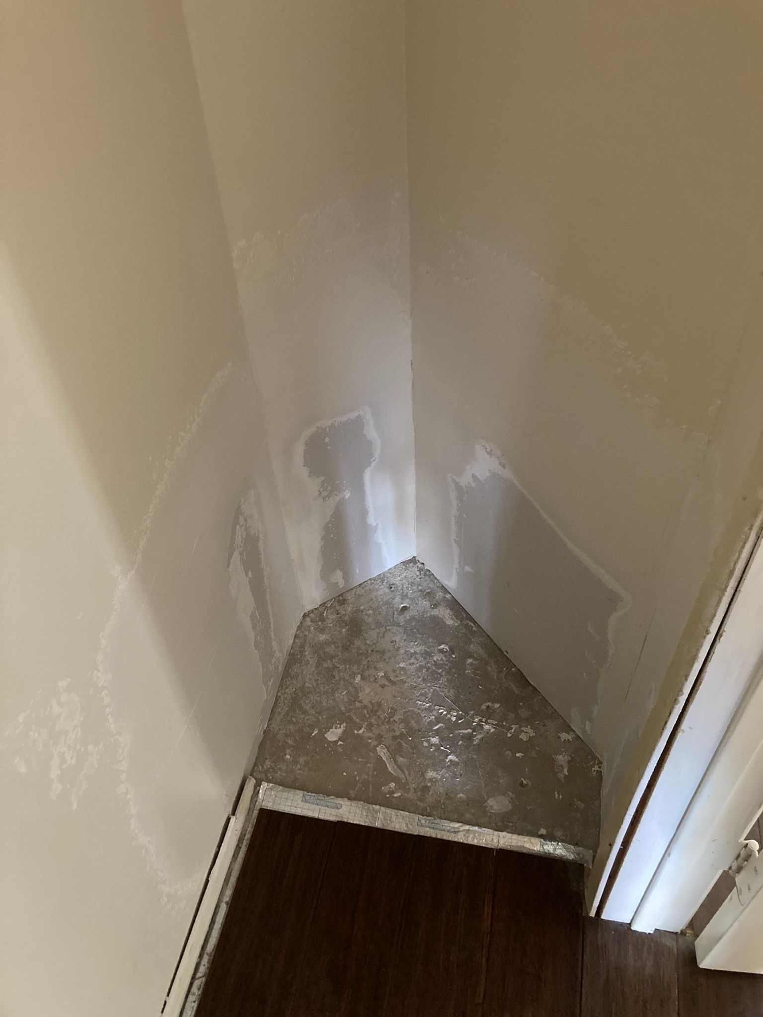 A corner of a room with a door and a staircase.