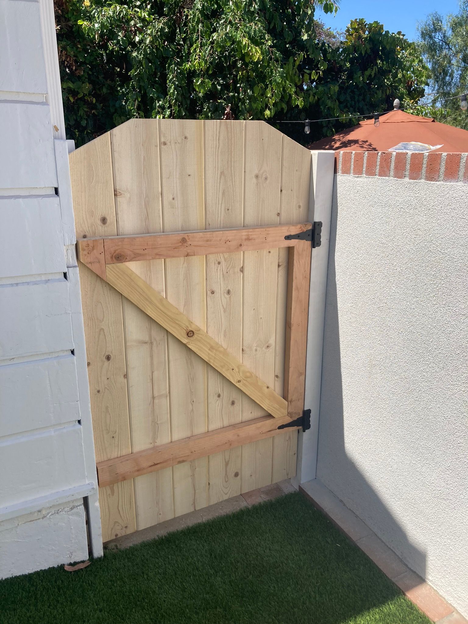 A wooden gate is sitting on top of a lush green lawn.
