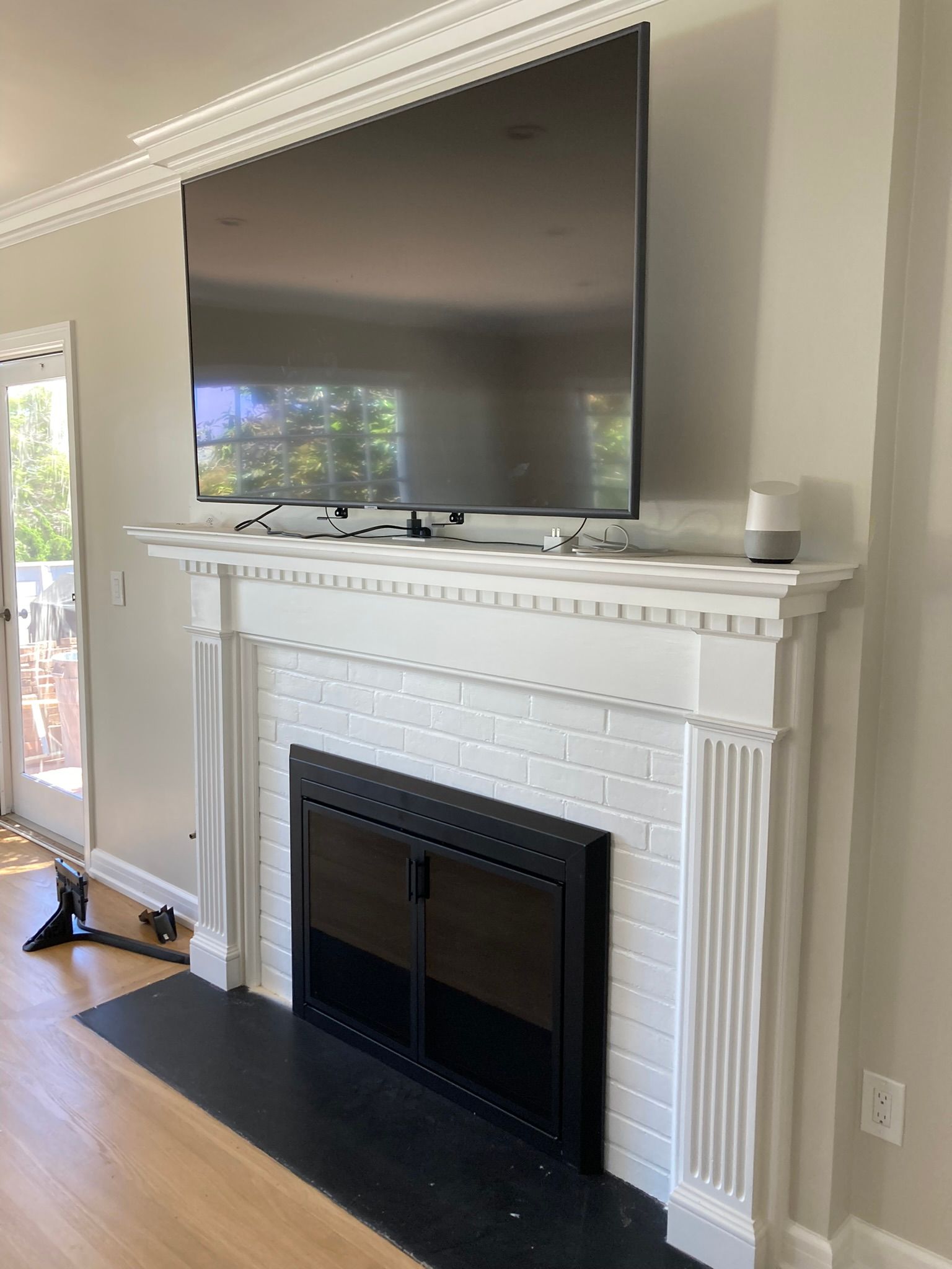 A living room with a fireplace and a flat screen tv mounted on the mantle.