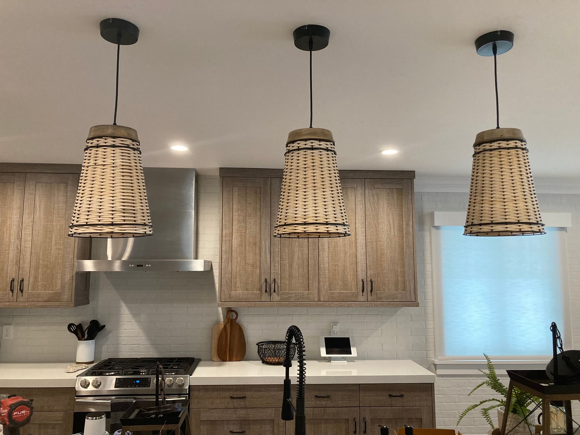 A kitchen with three wicker pendant lights hanging from the ceiling.