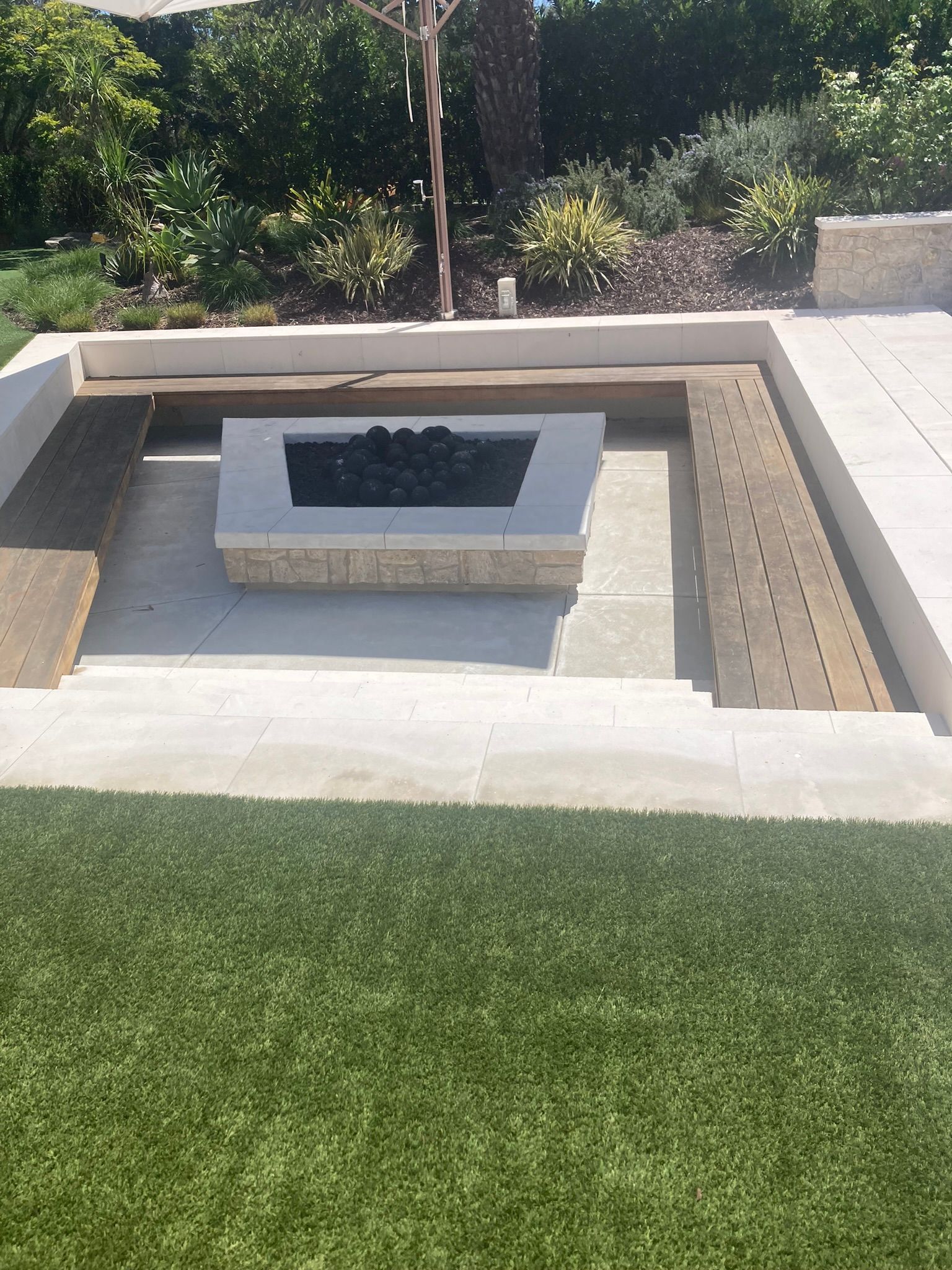 A fire pit is sitting in the middle of a lush green lawn.