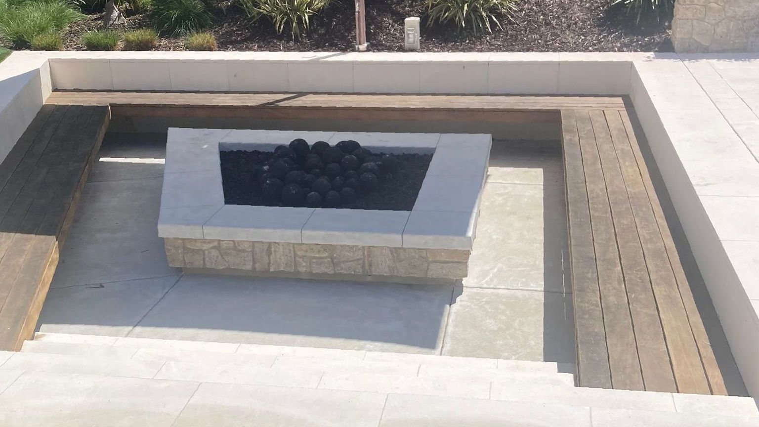 A fire pit is sitting in the middle of a lush green lawn.
