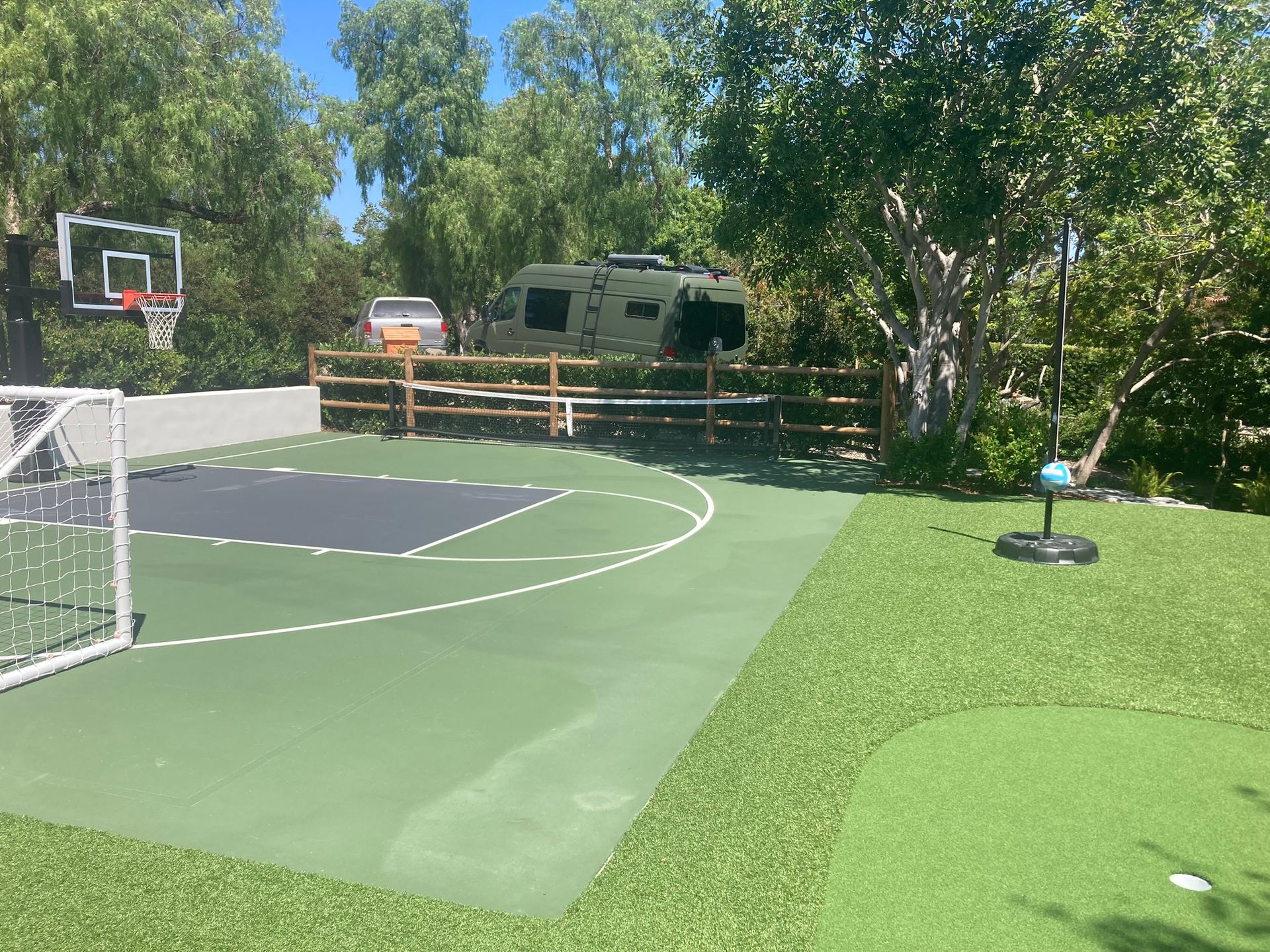 A basketball court with a rv parked in the background