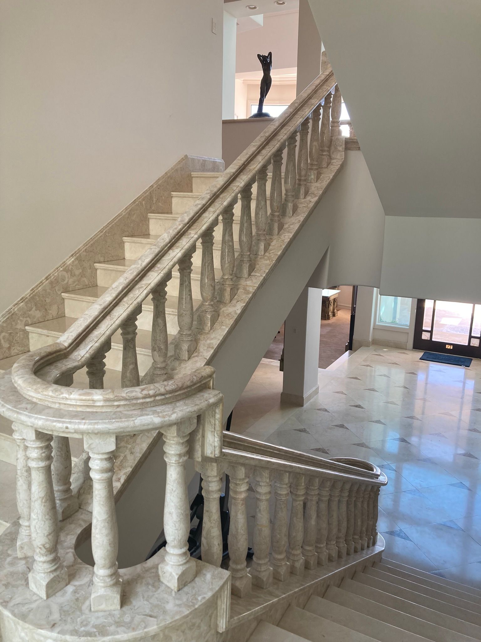 A staircase with a marble railing and a statue on top of it