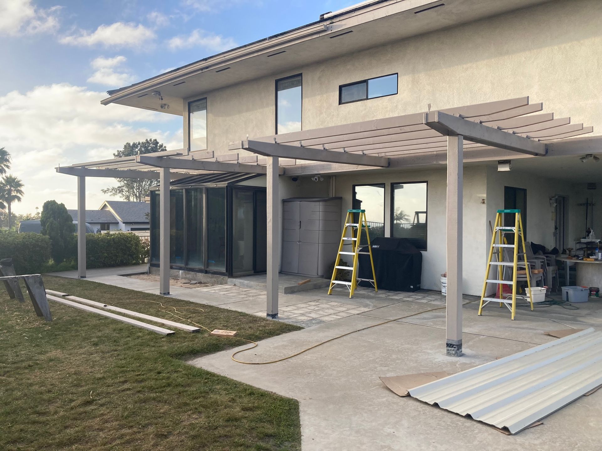 A house with a pergola being built in the backyard.