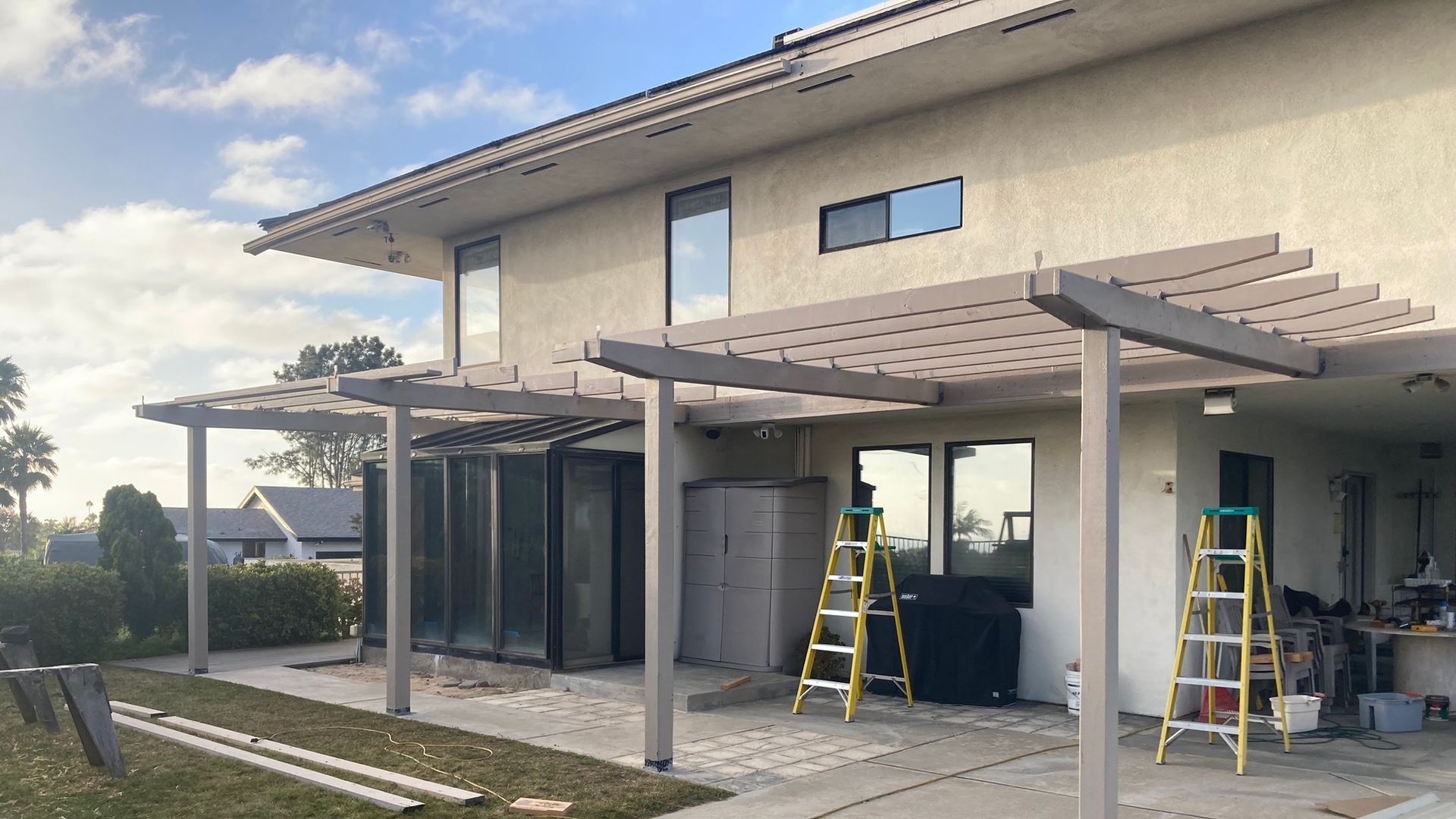 A house with a pergola being built in the backyard.