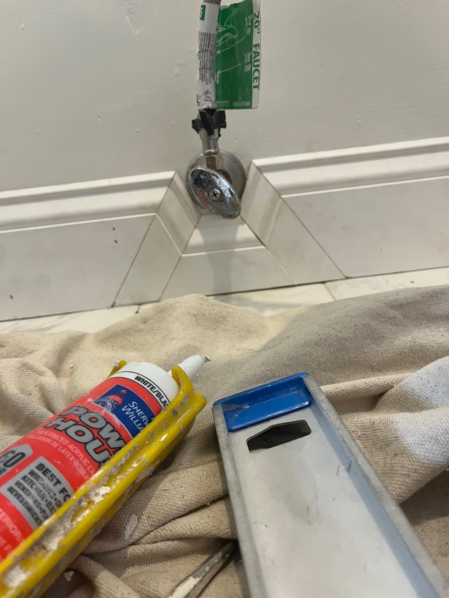 A bottle of glue is sitting on a towel next to a ladder.