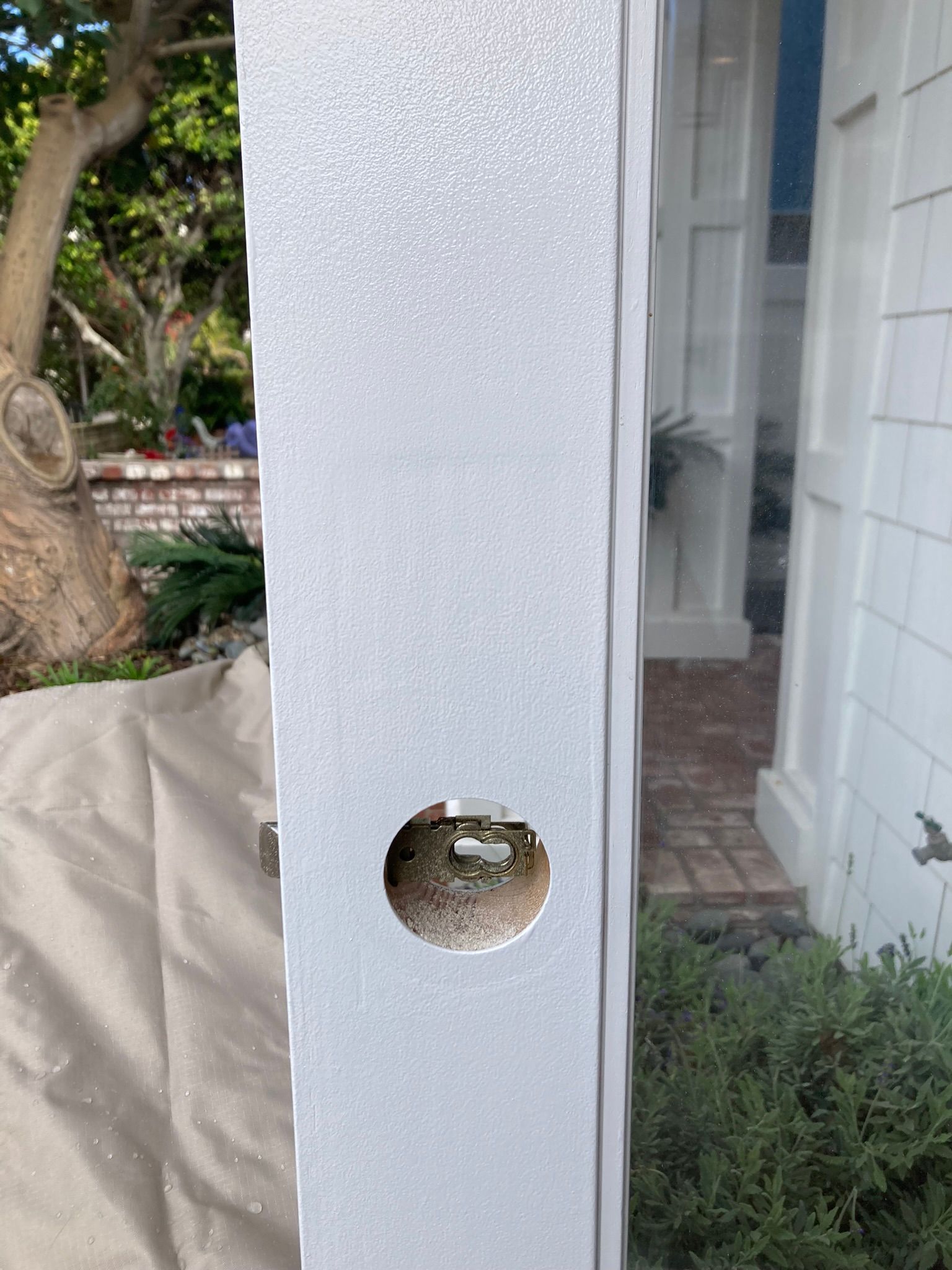 A white door with a hole in the middle of it.