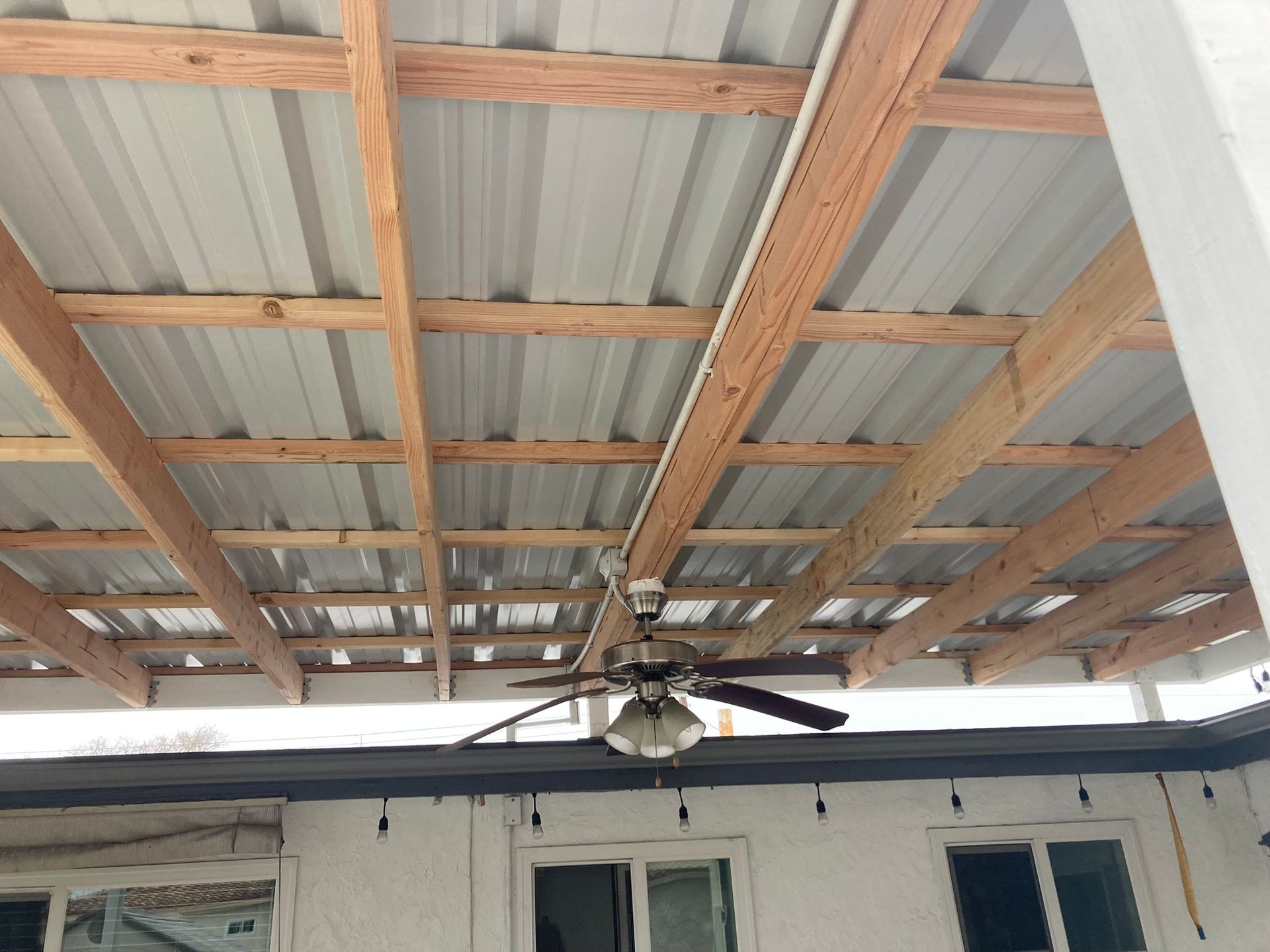 A ceiling fan is hanging from the roof of a building.