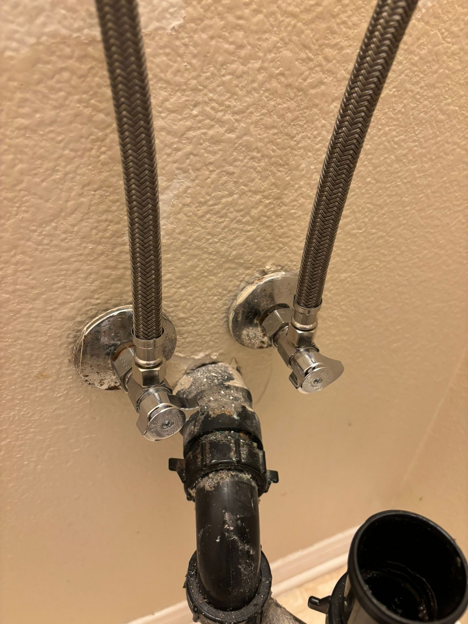 Plumbing under a bathroom sink: supply lines, shut-off valves, drain pipes.