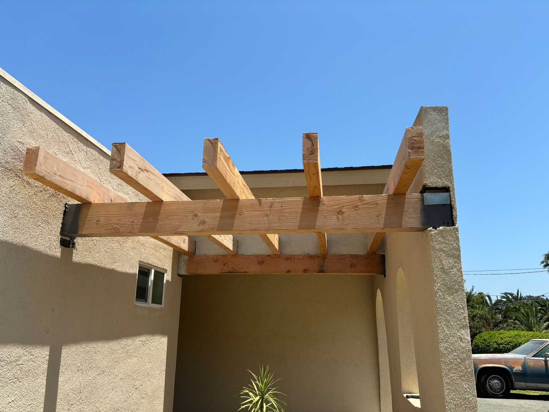 A pergola is being built on the side of a building