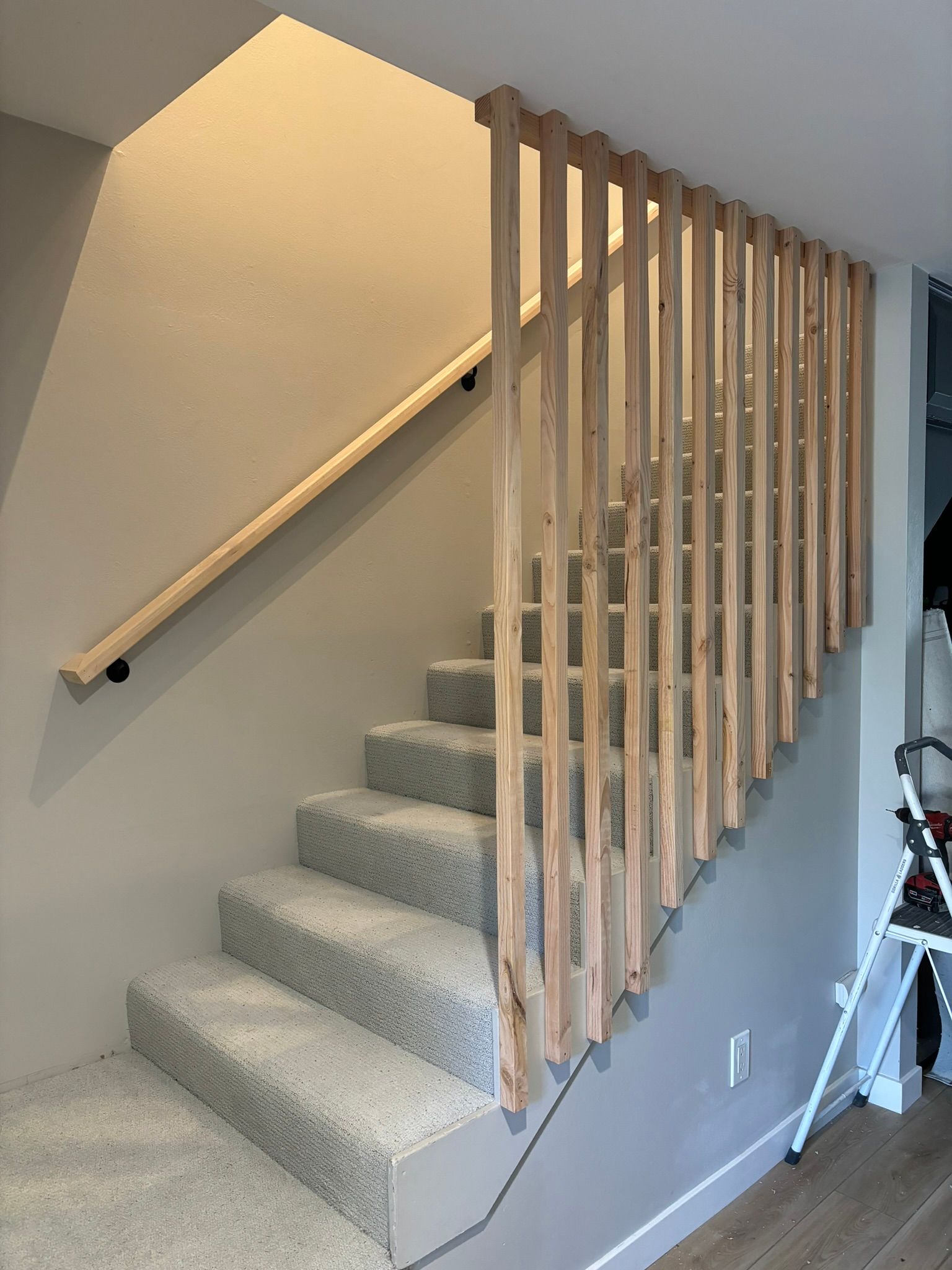 A staircase with carpeted steps and a wooden railing.