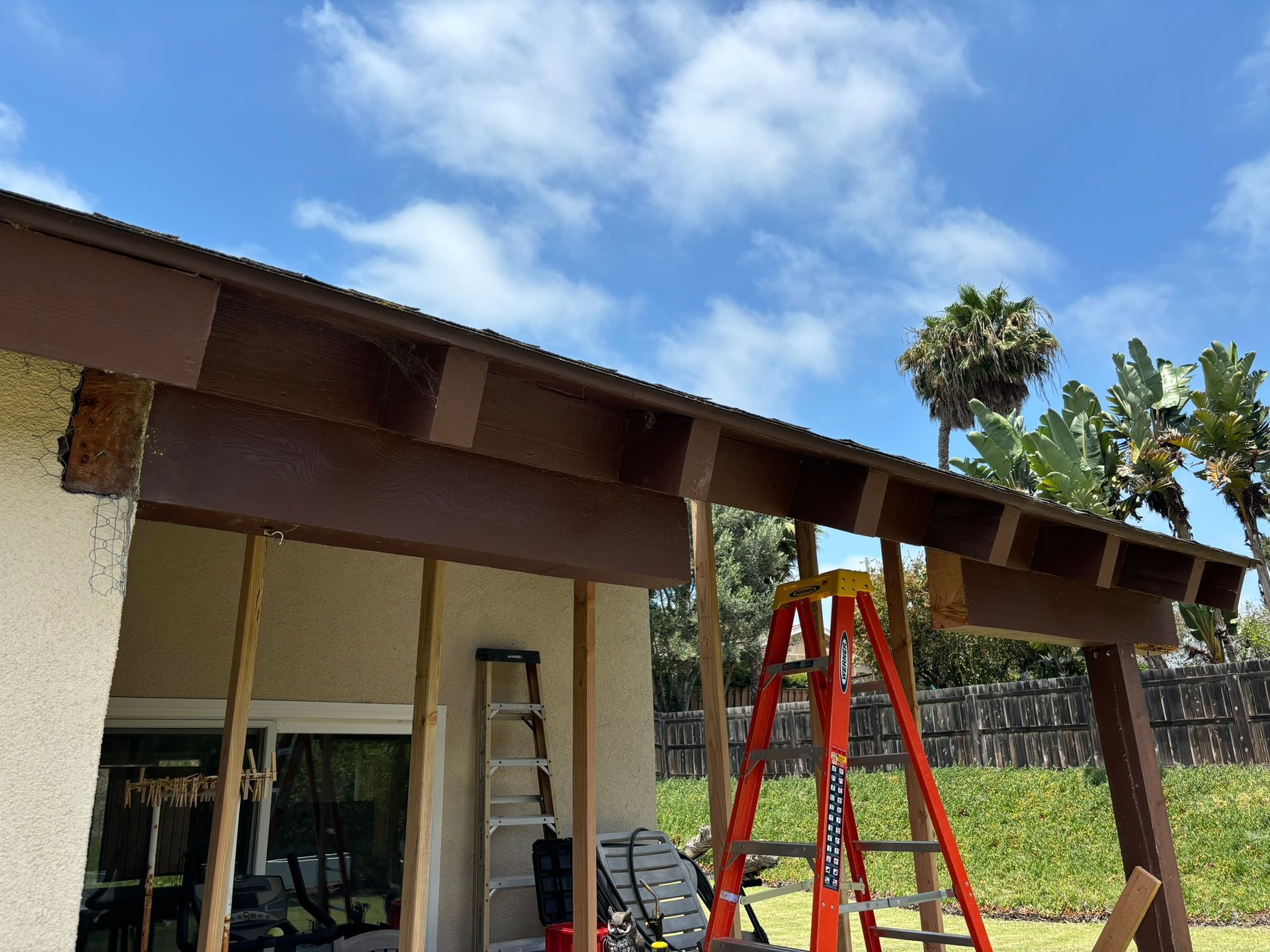 A ladder is sitting in front of a house under construction.