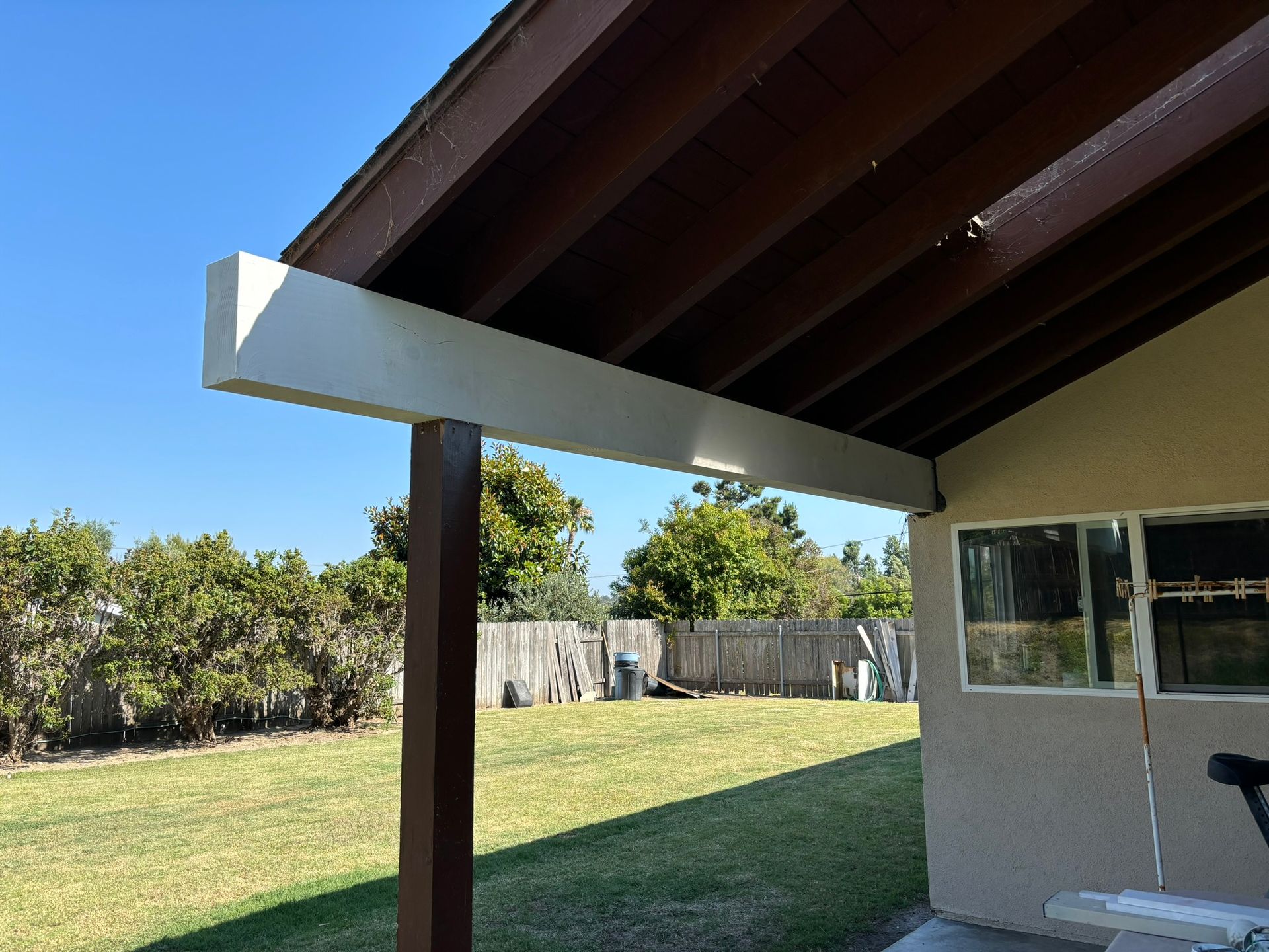 A house with a covered porch and a window in the backyard