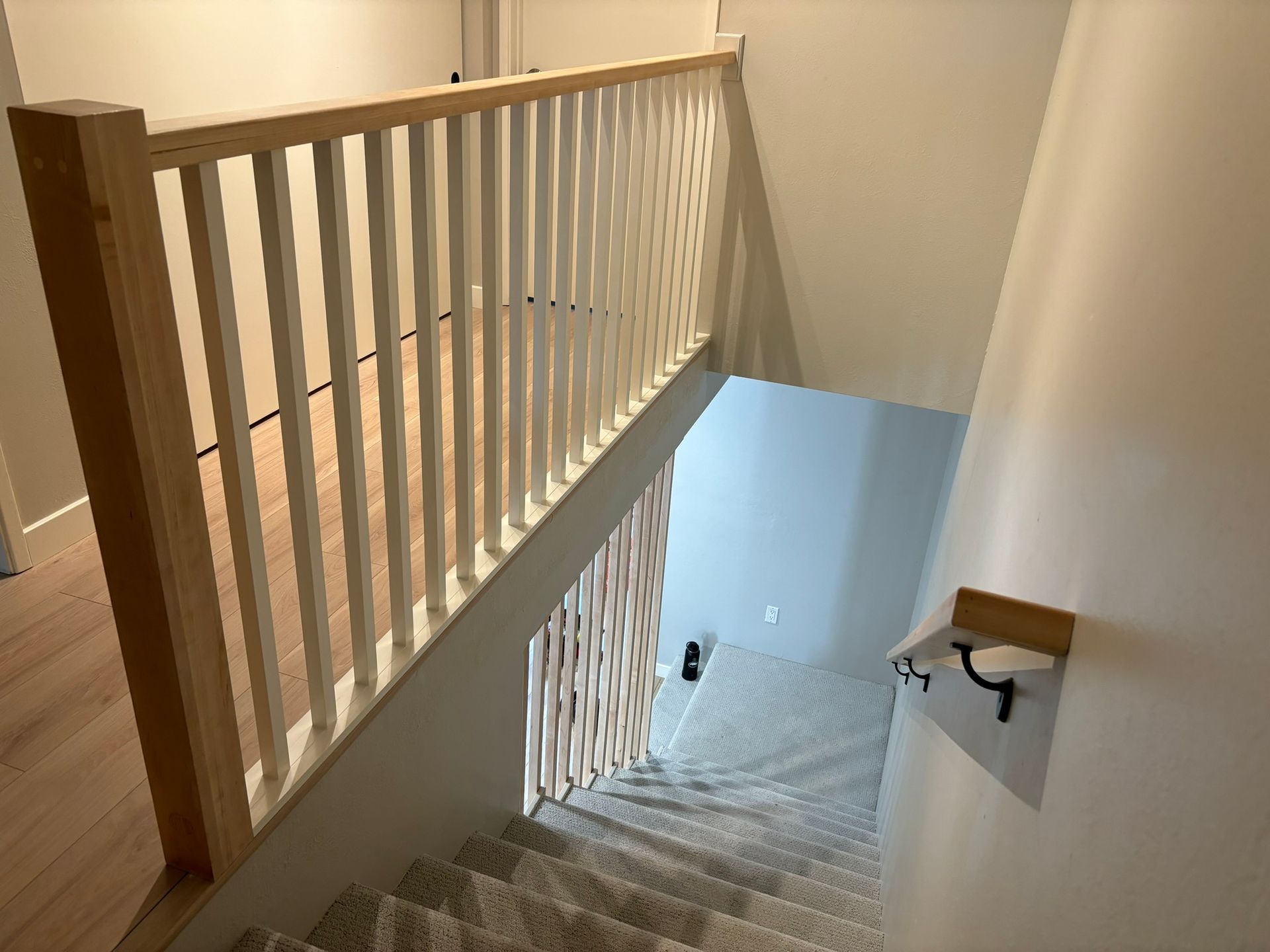 A staircase with a wooden railing leading up to the second floor of a house.