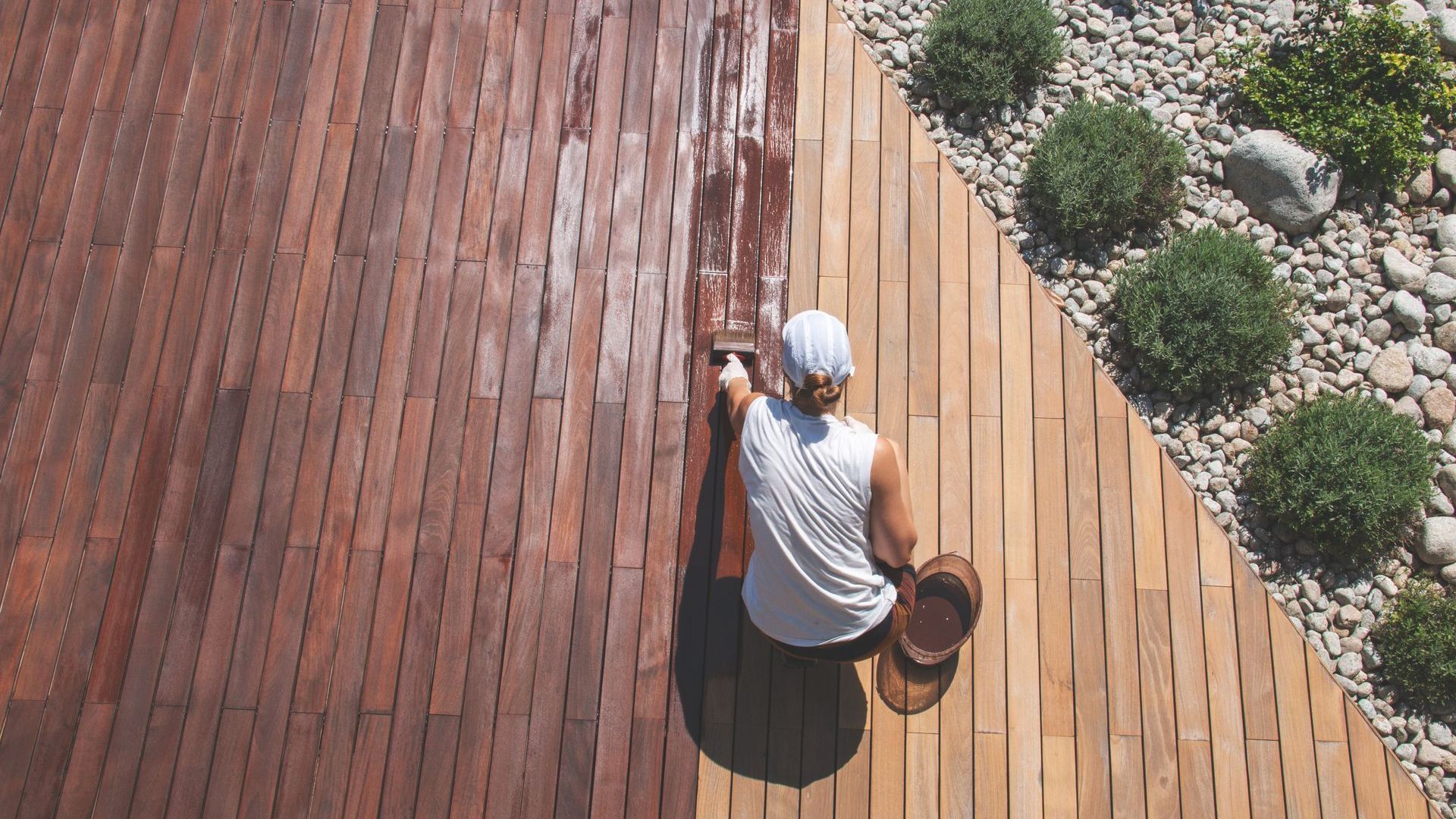 A man is working on a wooden deck.